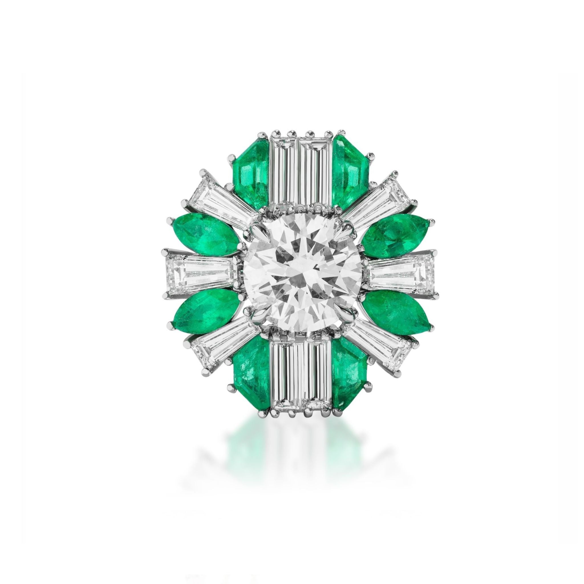 A luxurious ring featuring a large round diamond center, surrounded by baguette-cut diamonds and vivid green emeralds arranged in a symmetrical, floral-inspired design.