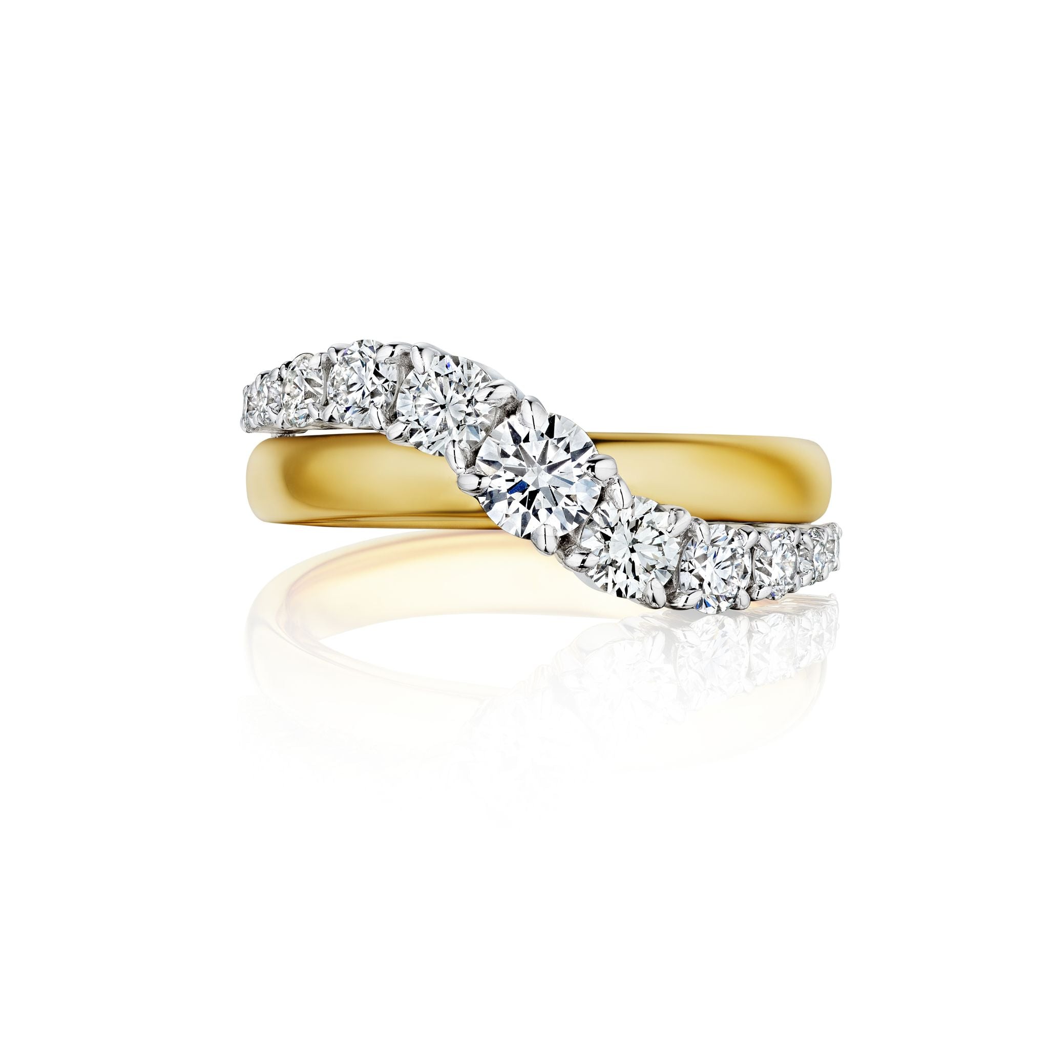 A hand with natural nails wears three rings: an emerald-cut diamond ring, a diamond eternity band, and a simple gold band, all stacked on the ring finger.