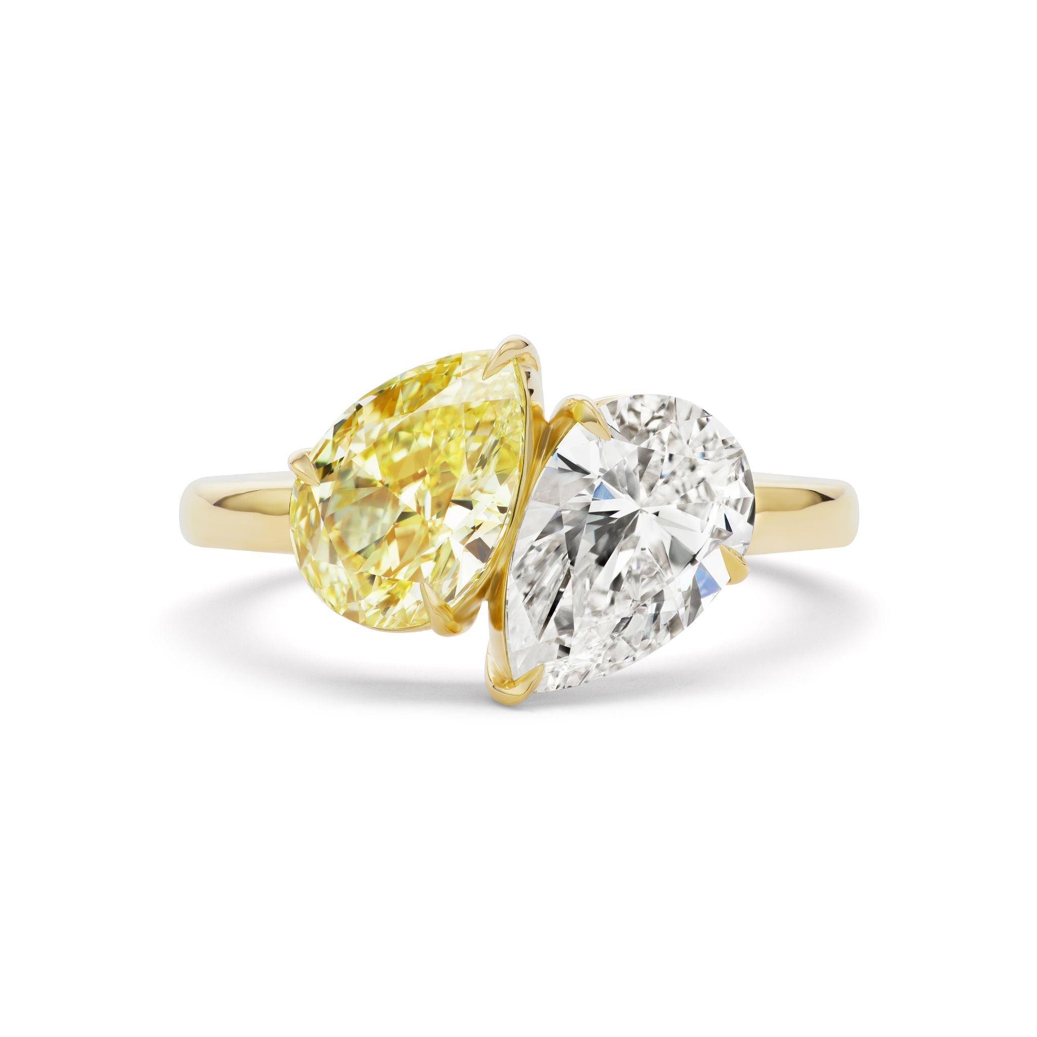 A gold ring featuring two pear-shaped gemstones: one yellow diamond and one white diamond, set side by side in an elegant, modern design.
