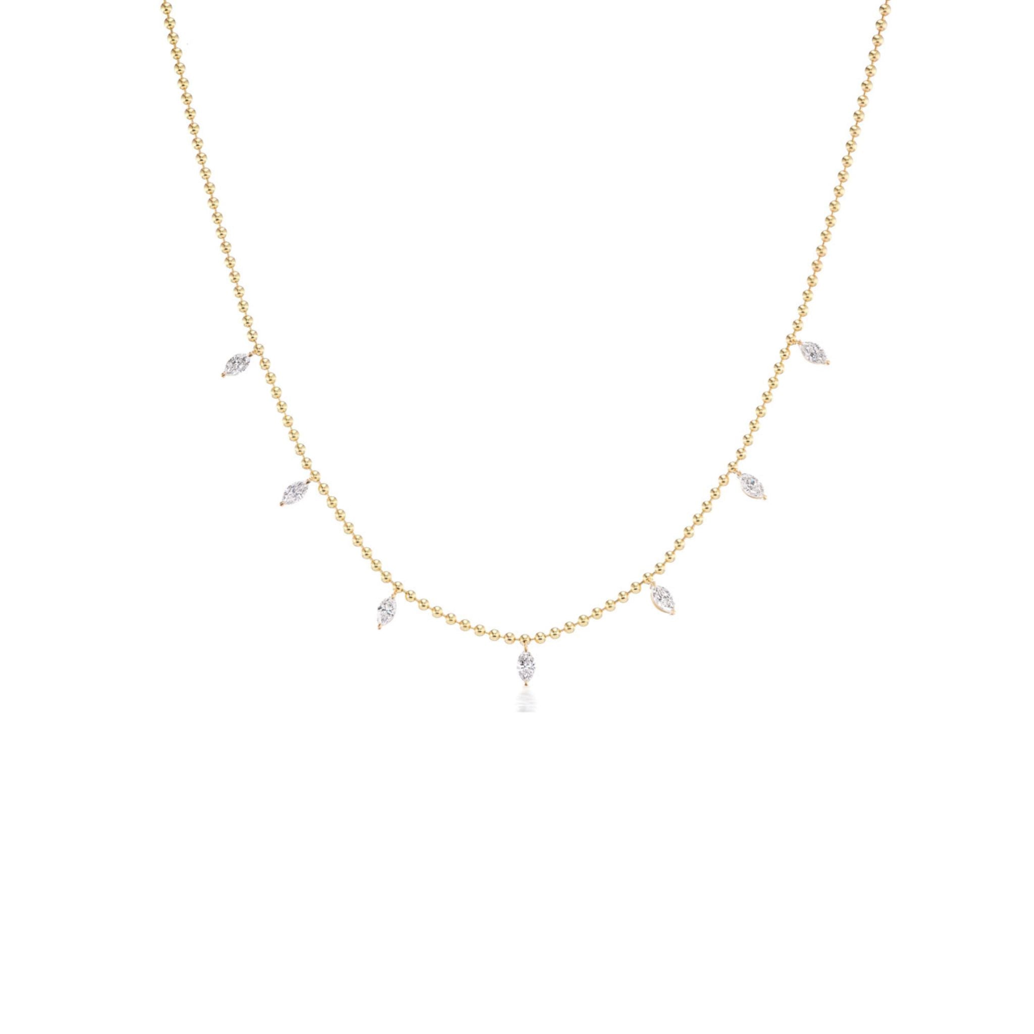 Delicate silver necklace with evenly spaced round diamonds set in bezels along a thin chain, displayed on a plain white background.