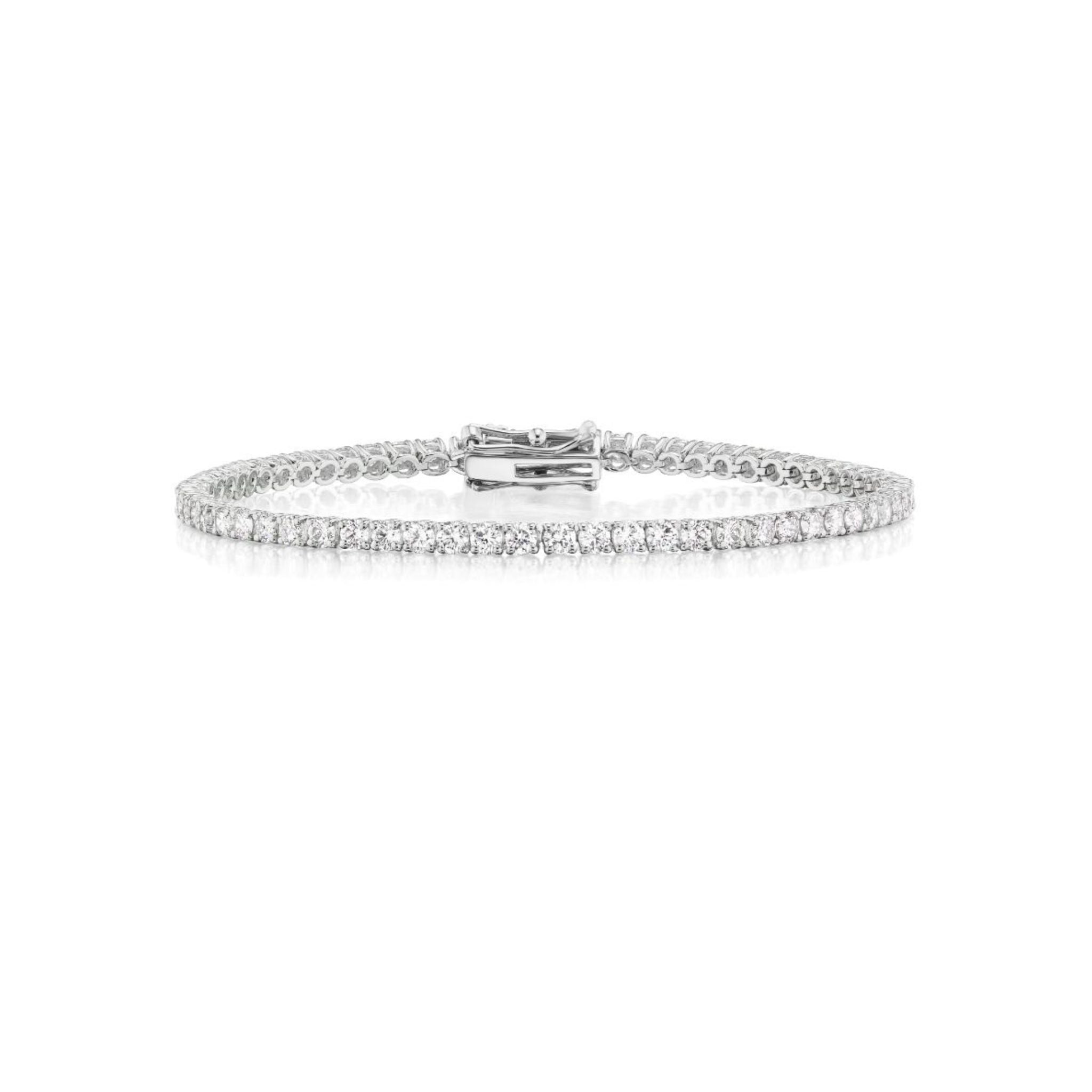 A delicate silver tennis bracelet adorned with a continuous row of small, sparkling diamonds, displayed on a white background.
