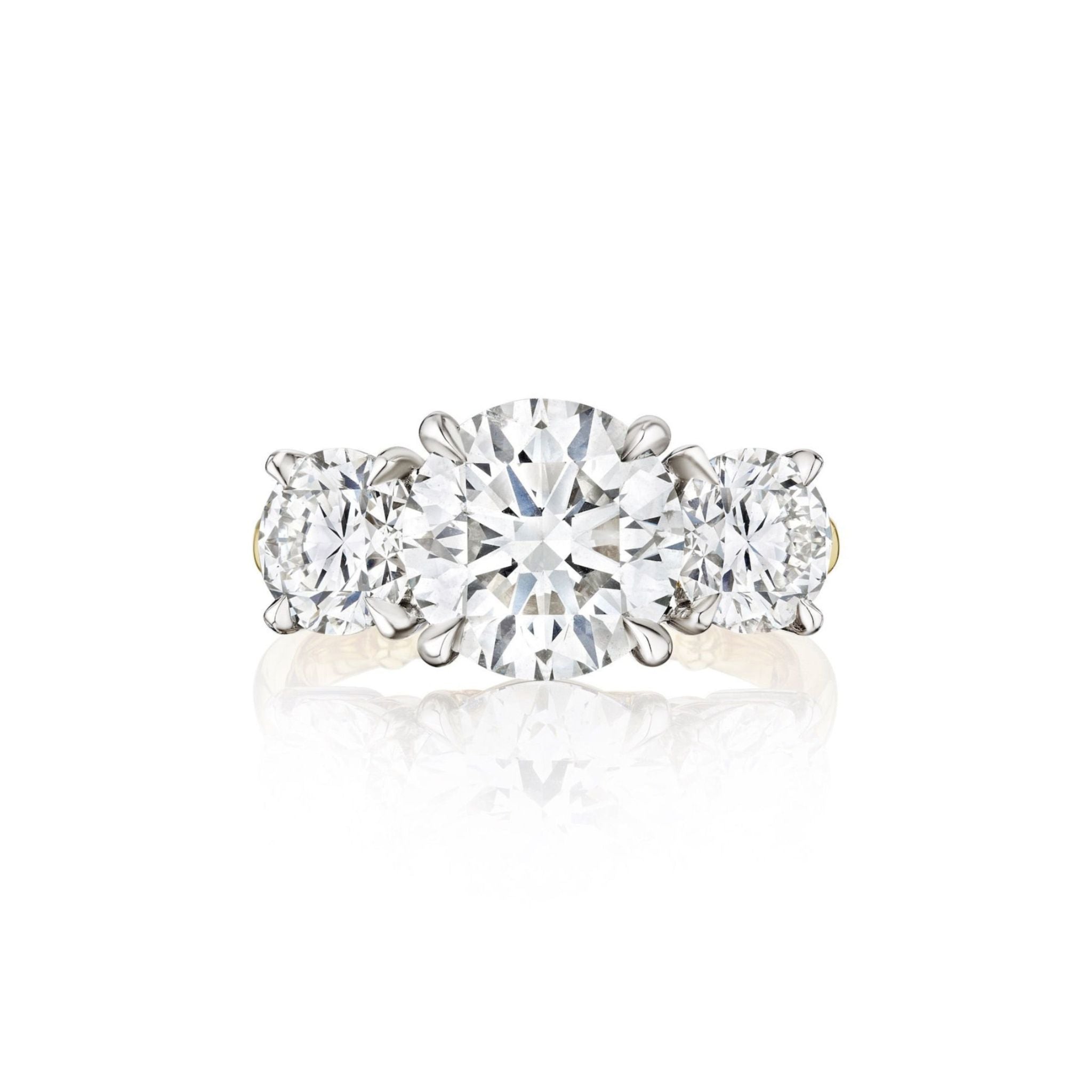 A three-stone diamond ring with round-cut diamonds set in a white metal band, displayed on a white background.