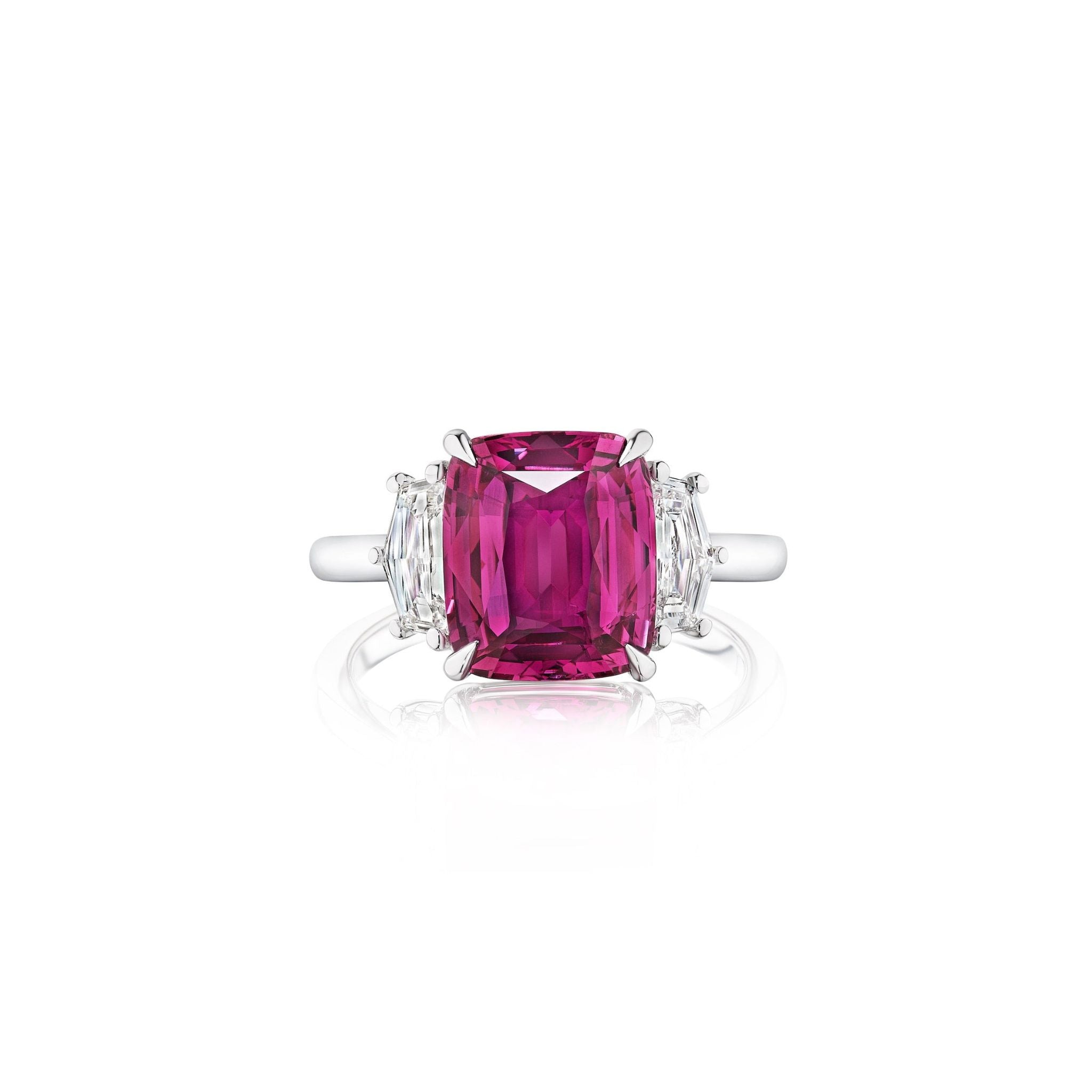 A silver ring featuring a large cushion-cut pink gemstone at the center, flanked by two smaller rectangular clear diamonds on each side, displayed on a white background.
