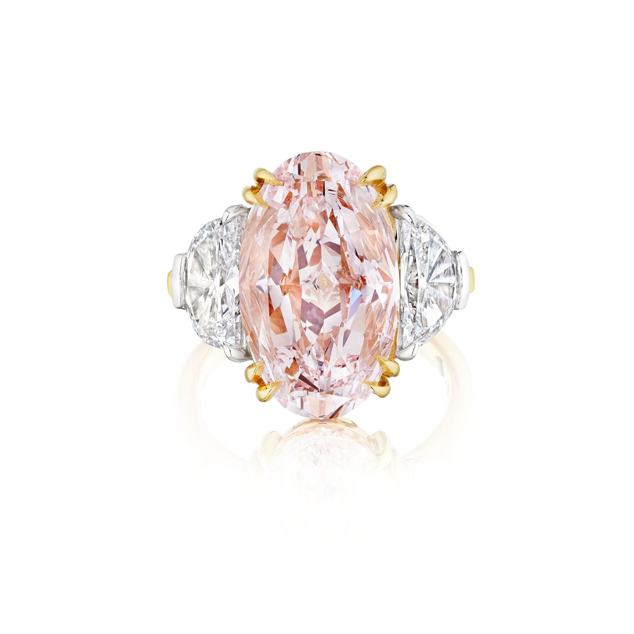 A gold ring featuring an oval pink diamond in the center, flanked by two triangular white diamonds on either side, displayed against a white background.