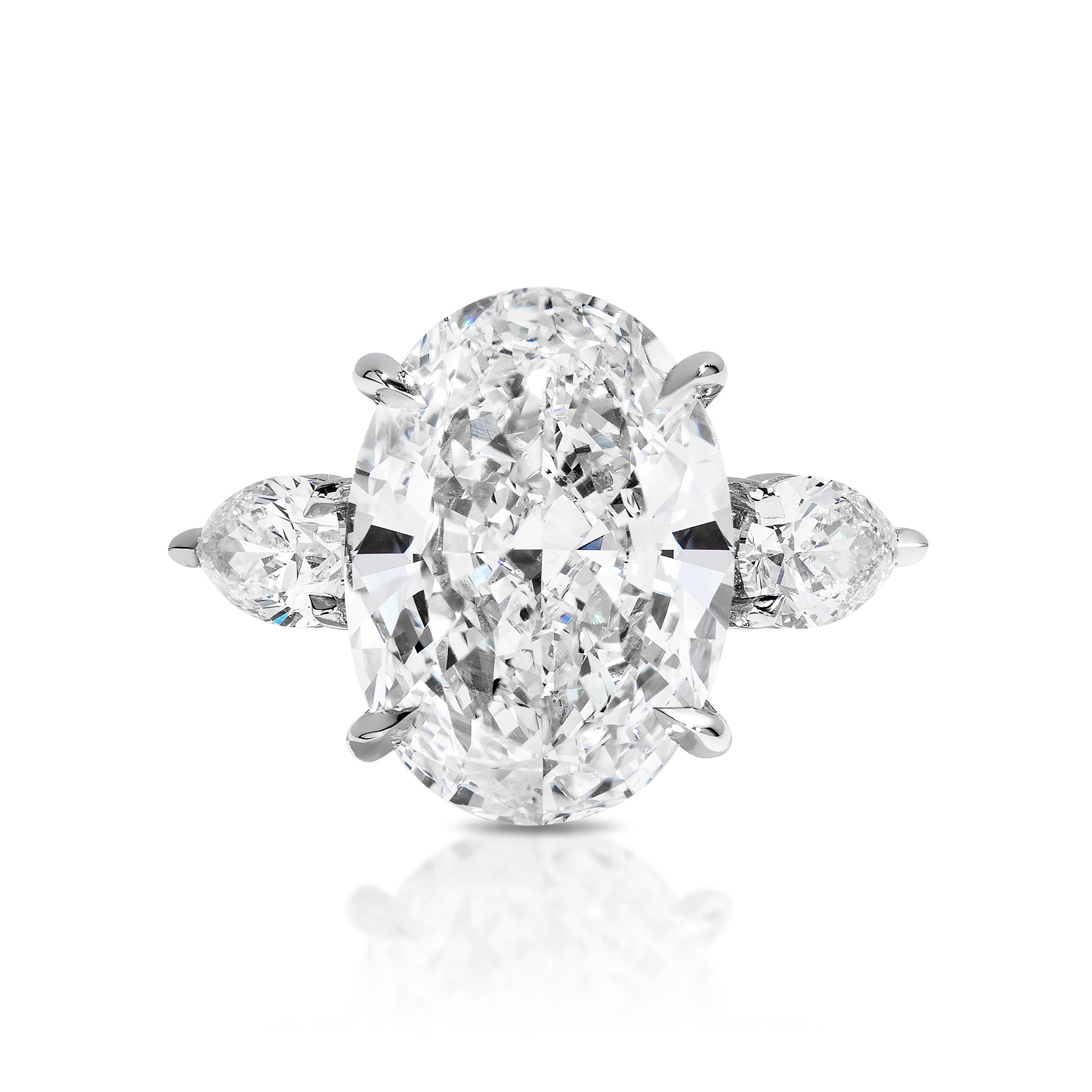 An Oval Diamond Engagement Ring with Pear Side Stones in white gold, featuring a large oval-cut diamond center and pear-shaped side stones, displayed on a plain white background.