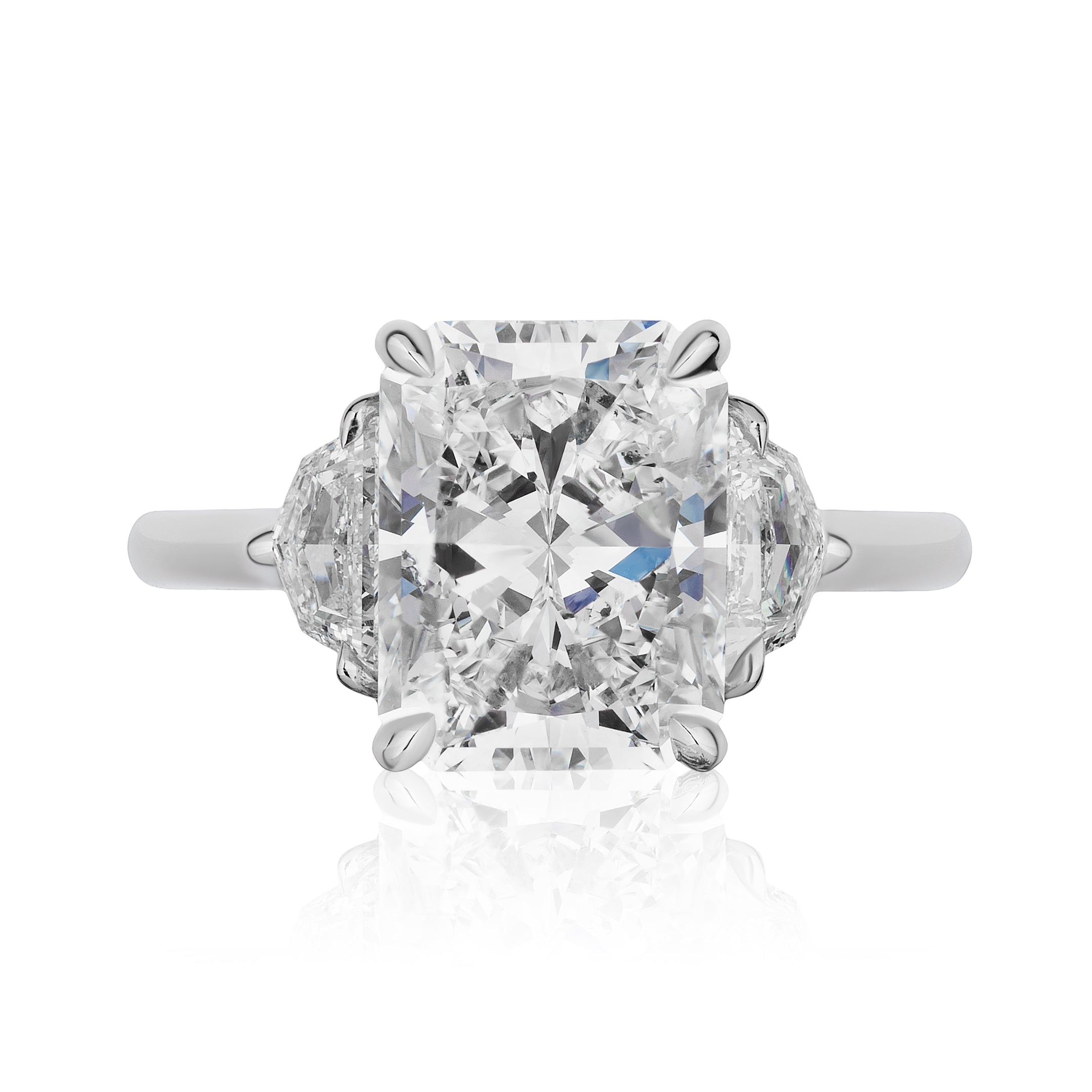 The Radiant Cut Diamond Engagement Ring with Epaulette Side Stones features a striking rectangular center diamond flanked by unique epaulette-shaped diamonds, all set on a polished platinum band—ideal for those seeking a distinctive bridal ring.