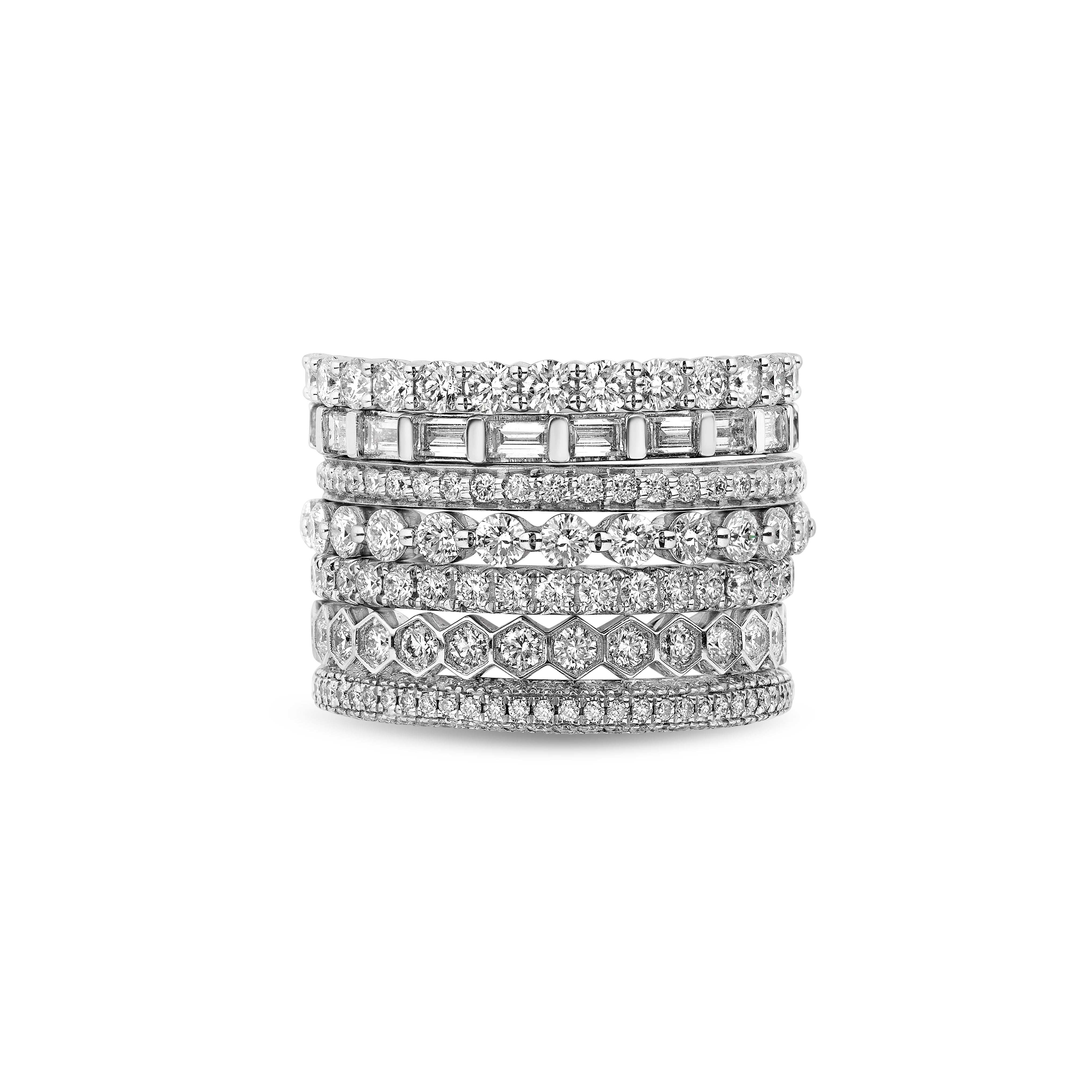 Six Stackable Diamond Rings, each featuring a unique band design and sparkling diamonds, are arranged vertically against a plain white background.