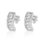 The J Hoop Earring in White Gold features bracket bezel set emerald cut diamonds in a sleek, curved design with butterfly backings, crafted in 18K white gold.
