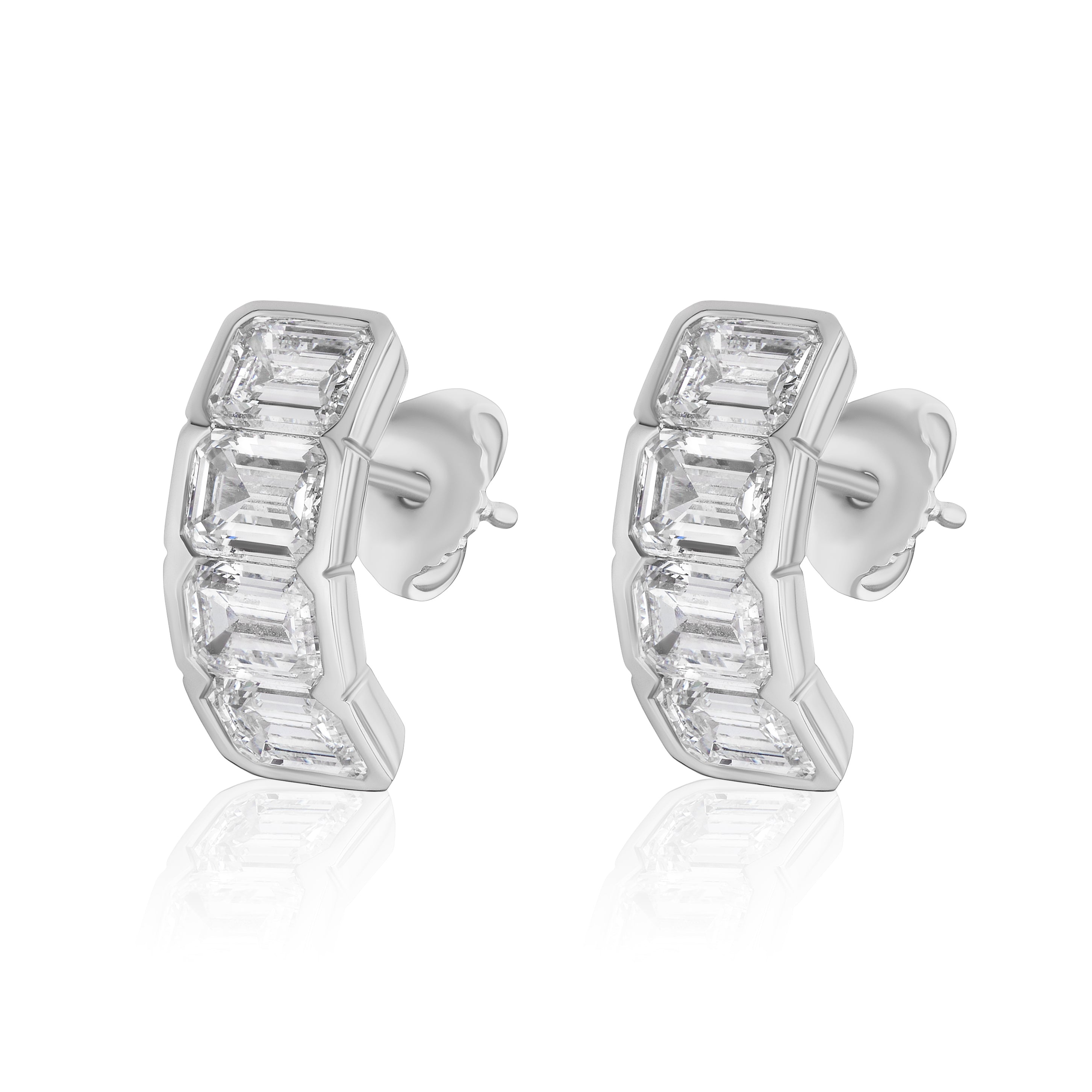 The J Hoop Earring in White Gold features bracket bezel set emerald cut diamonds in a sleek, curved design with butterfly backings, crafted in 18K white gold.
