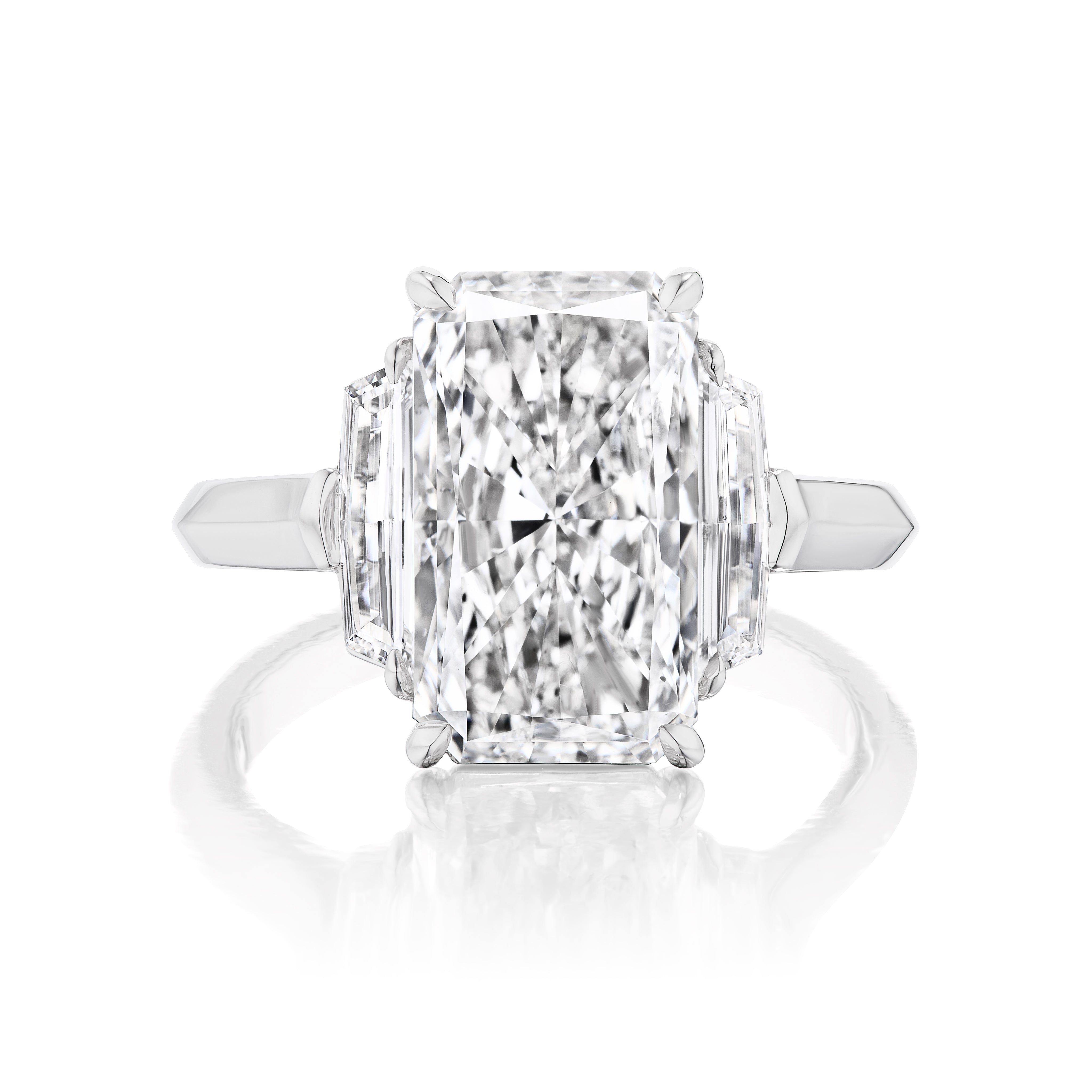 The Elongated Radiant Cut Diamond Engagement Ring with Epaulette Side Stones features a polished white metal band, offering timeless bridal elegance, beautifully displayed against a white background.