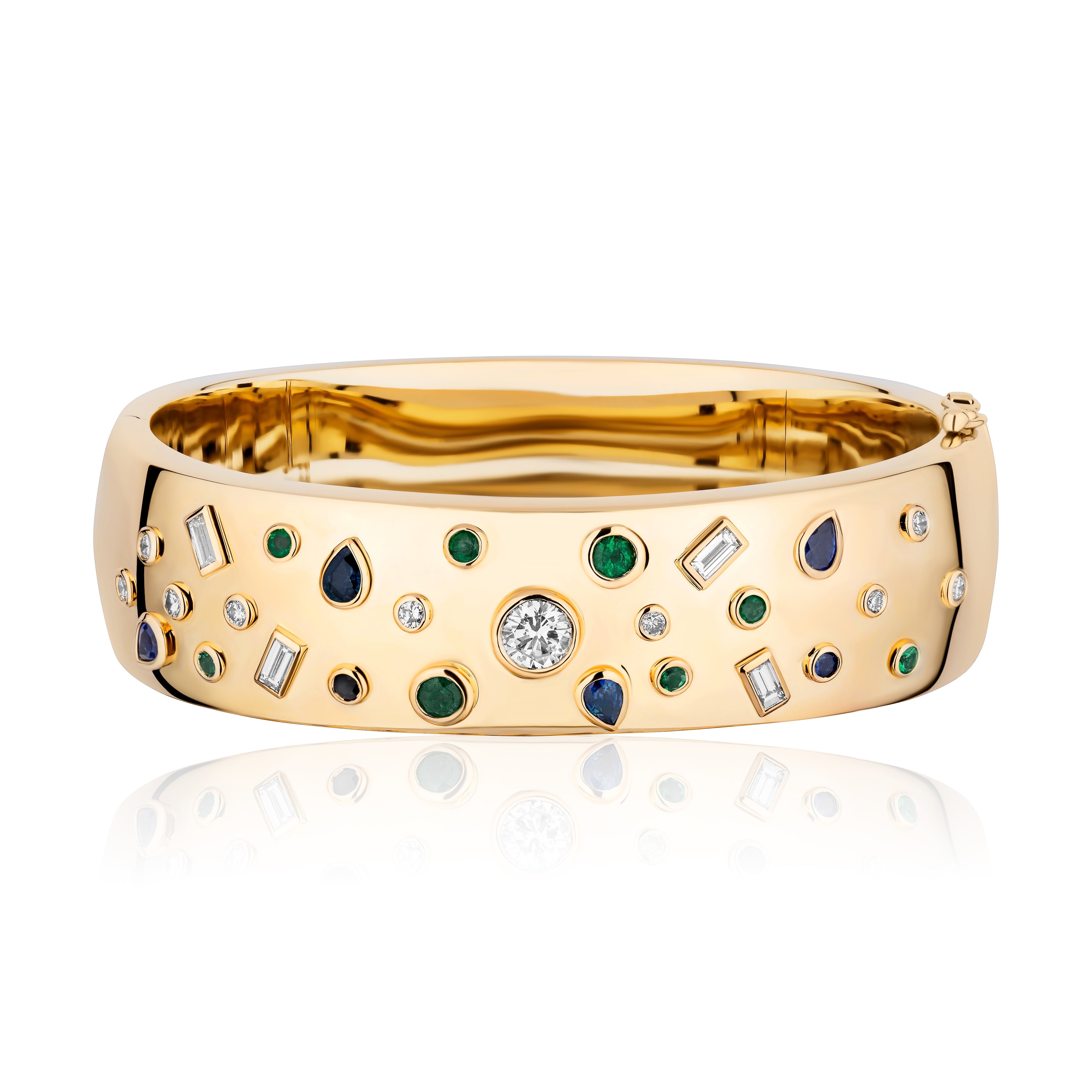 The Bezel Set Mixed Shape Emerald, Diamond, and Sapphire Cuff in Yellow Gold features round, pear, and baguette gems set in a scattered pattern on an 18K yellow gold surface.