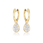 Pear Diamond Hoops: 18k yellow gold earrings with dangling SI clarity pear-shaped diamonds, shown on a white background.