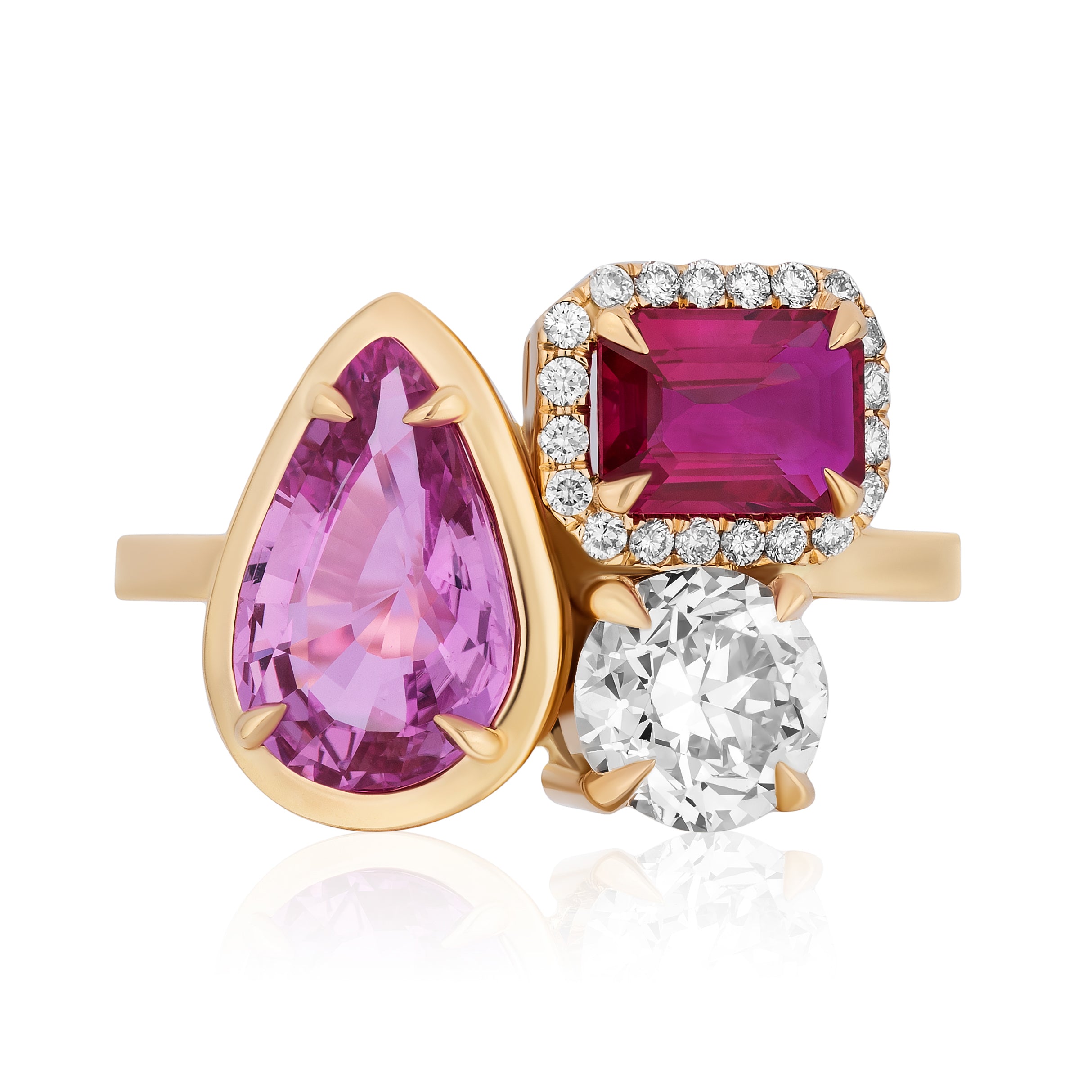 The Cluster Ring in yellow gold features a bezel-set pear shape and pavé emerald cut pink sapphires, along with a round white diamond.