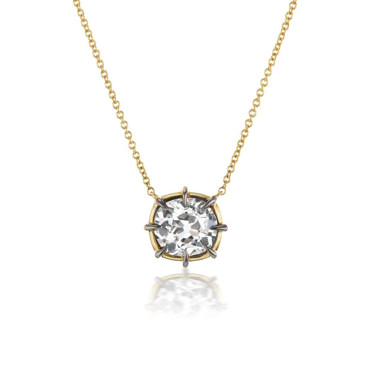 The Cushion Cut Diamond Collet Pendant in Yellow and Blackened Gold features a sparkling cushion cut diamond set in 18K yellow gold, reflecting light beautifully and casting a gentle shadow beneath.