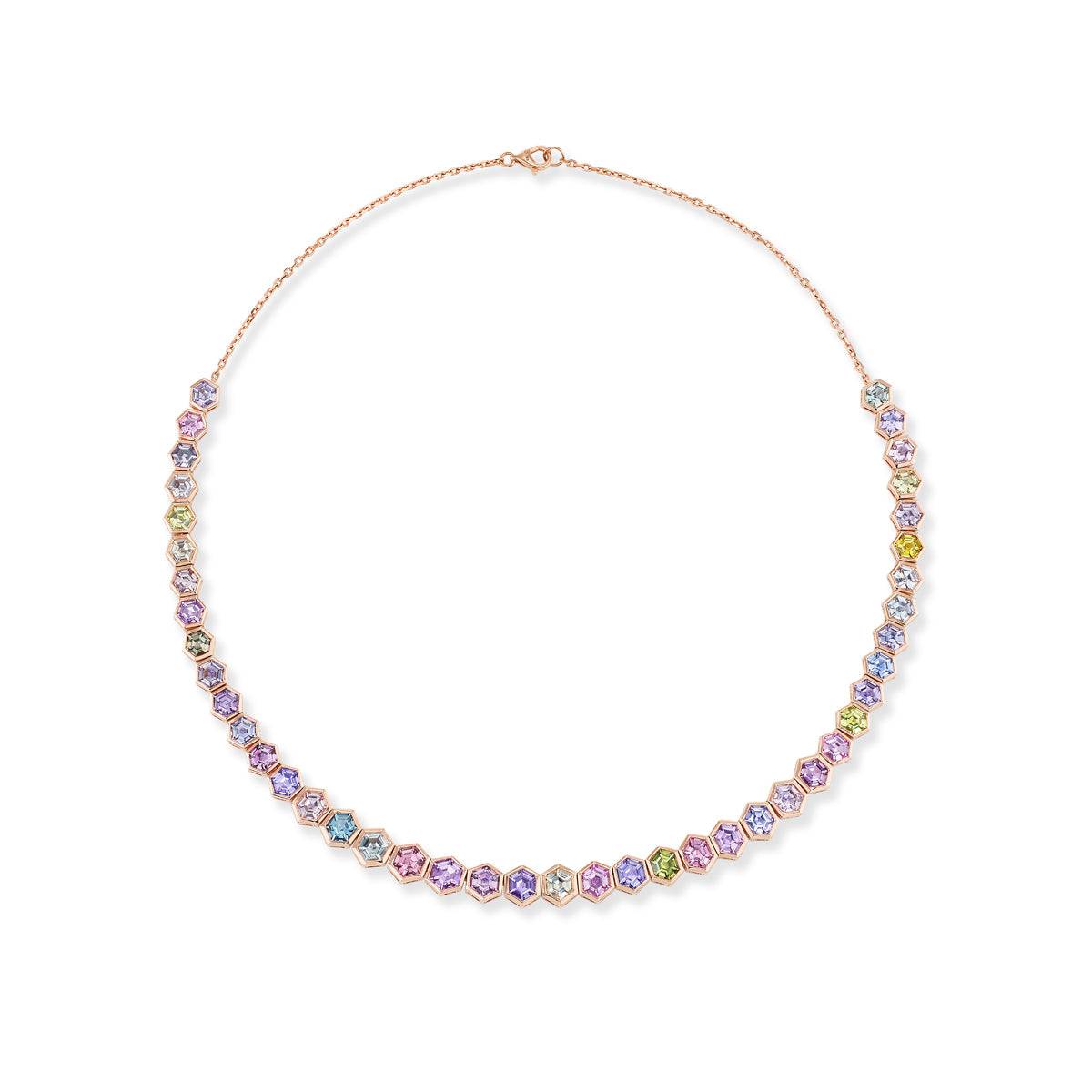 The Spectrum Collar Necklace features bezel-set multicolor hexagonal sapphires on an 18K rose gold chain, showcasing pastel hues of purple, blue, green, and yellow in a symmetrical pattern.