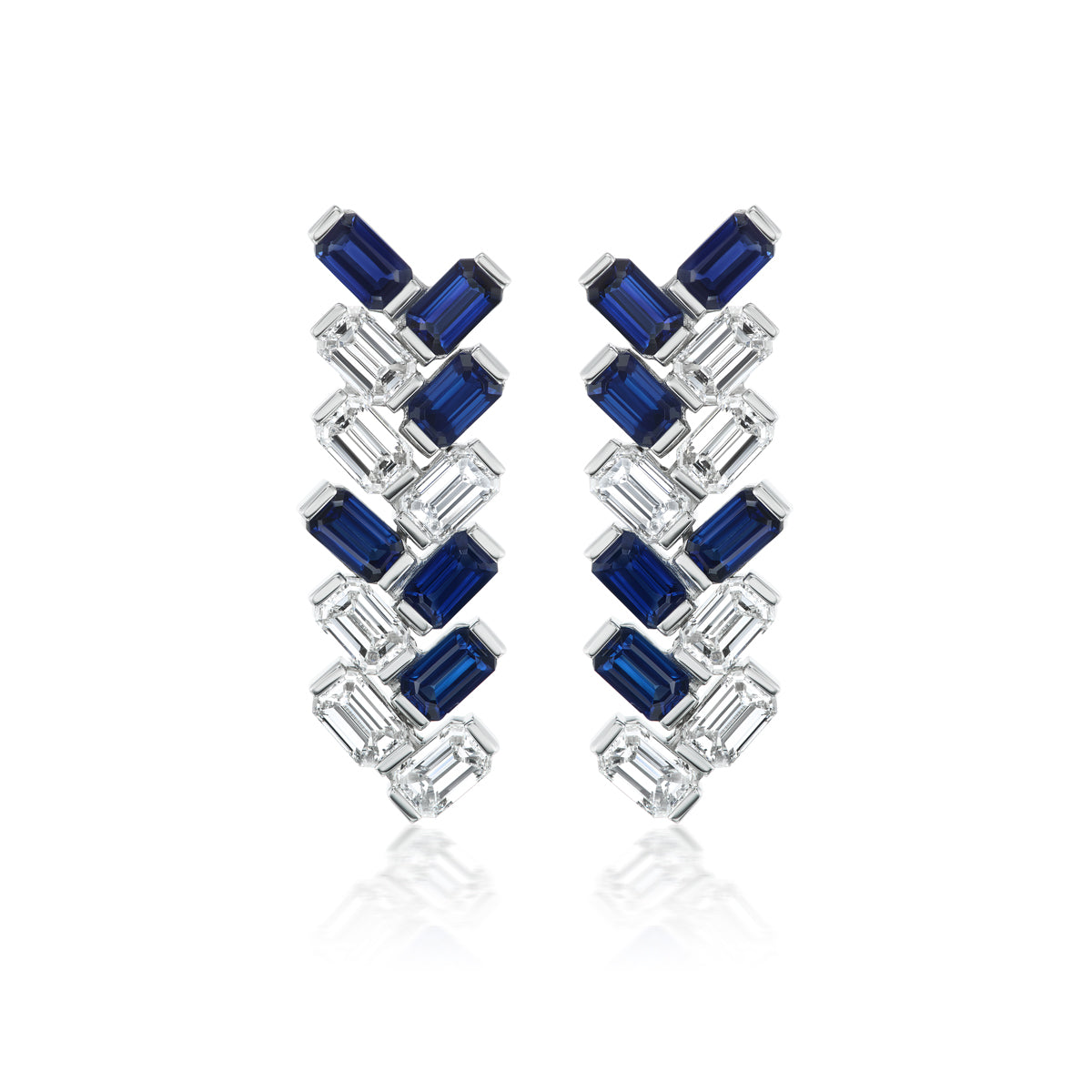 Alternating Half Bezel Emerald Cut Sapphire and Diamond Drop Earrings showcase blue sapphires and diamonds in a zigzag pattern, set in gleaming platinum, displayed on a white background.