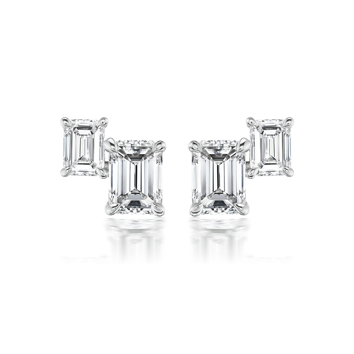 The Duo Studs in White Gold with Emerald Cut Diamonds feature two rectangular diamonds set in 18K white gold prongs, shown on a white background.