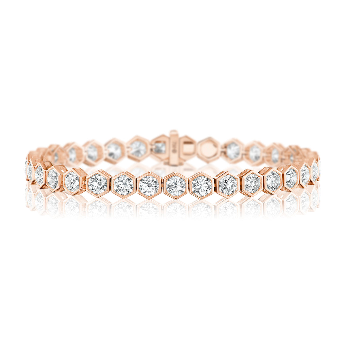 The Large Hexagon Bezel Set Diamond Tennis Bracelet features round-cut diamonds in hexagonal links, crafted from 18K rose gold, and is displayed on a white background.