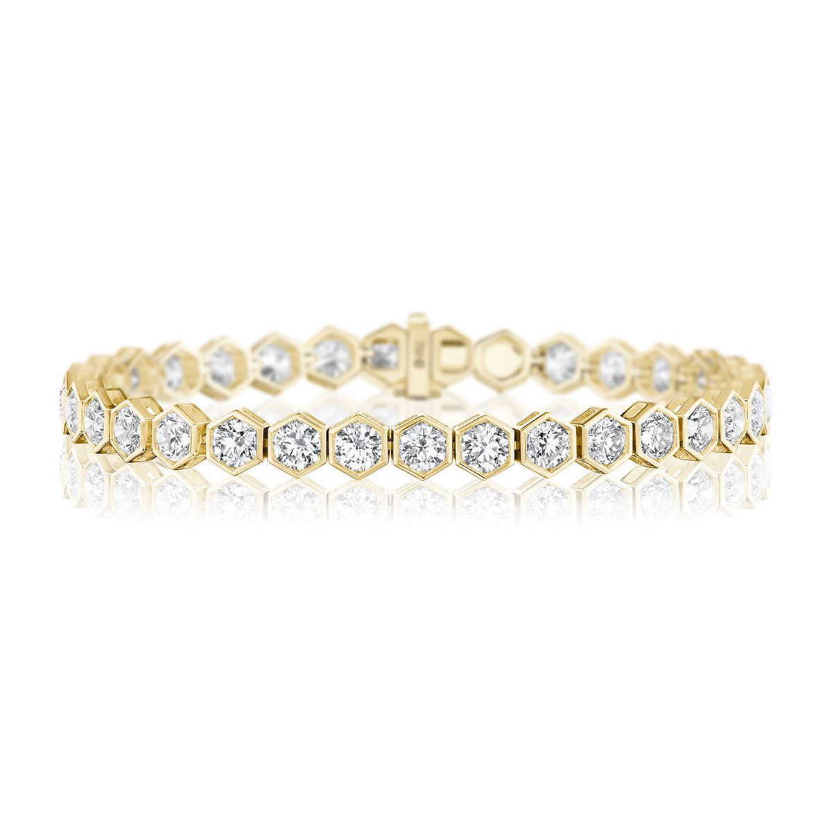 The Large Hexagon Bezel Set Diamond Tennis Bracelet in 18K gold features hexagonal links, each with a round diamond, and is displayed on a white background.