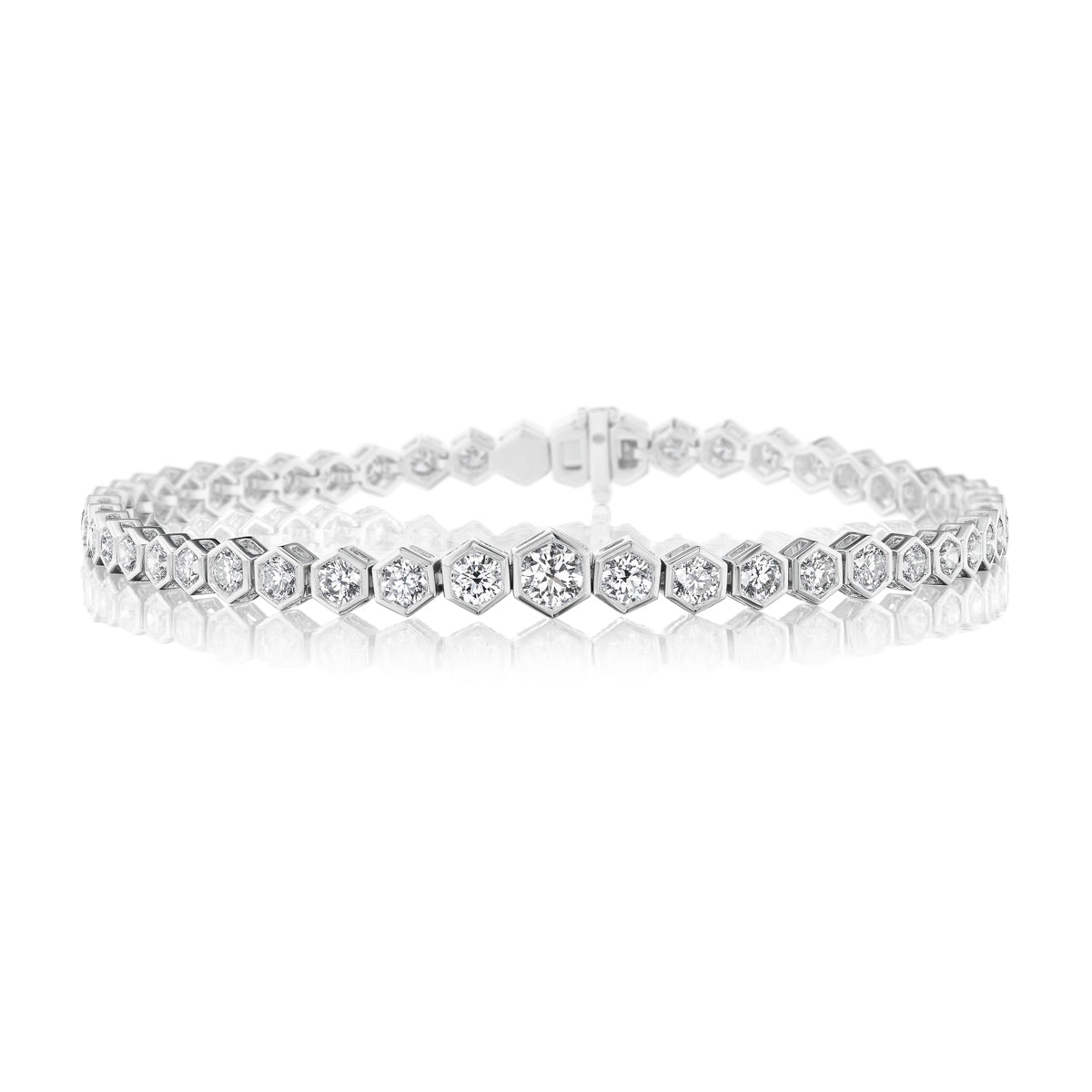 The Graduated Hexagon Bezel Set Diamond Tennis Bracelet in 18K white gold features hexagonal links, each with a round brilliant diamond, shown against a white background.