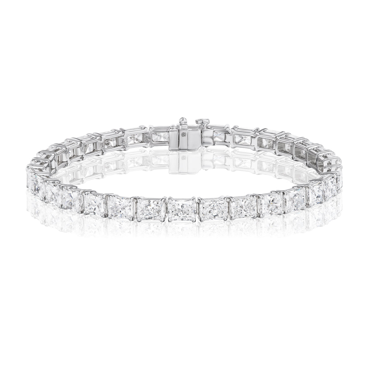 The East-West Radiant Cut Diamond Tennis Bracelet features radiant cut diamonds set in 18K white gold with a secure clasp, beautifully displayed on a white background to highlight its timeless elegance.