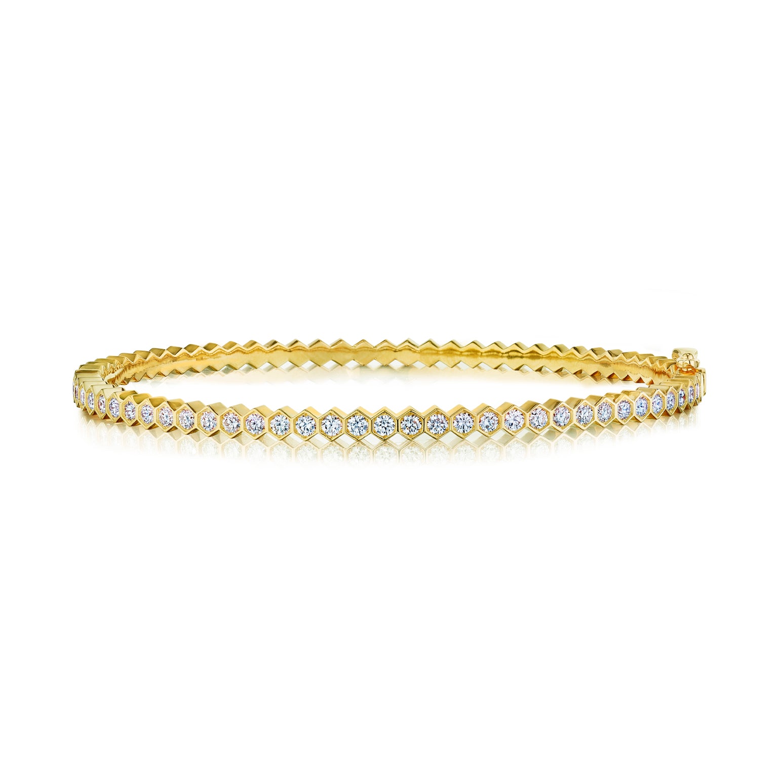 The Hexagon Bezel Set Diamond Bangle is a sleek 18k gold piece featuring a single row of round, white diamonds in bezel settings along the outer edge, shown on a white background.
