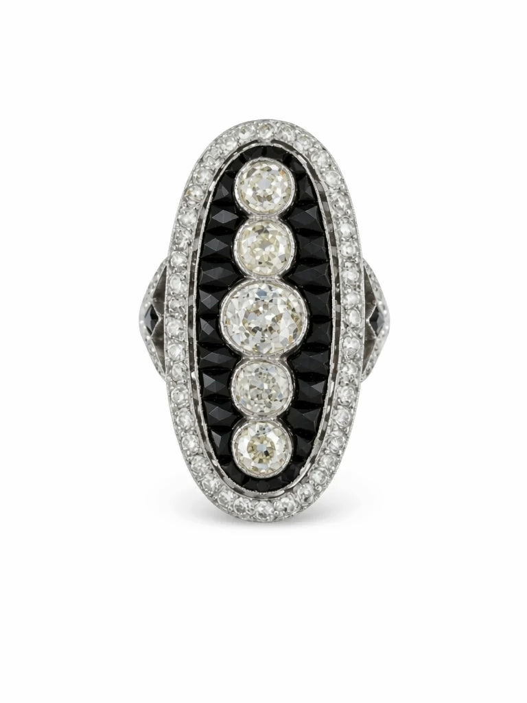 The Onyx and Diamond Ring showcases an elongated oval design with five old mine-cut diamonds in the center, bordered by calibré-cut onyx and a halo of small white diamonds, all set in platinum in classic 1930s style.