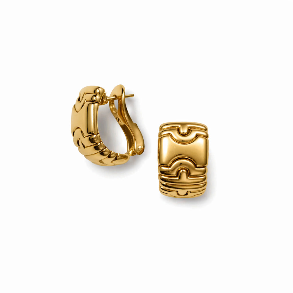 A pair of Bulgari "Parentesi" earclips in bold 18K yellow gold, featuring geometric, engraved patterns; one earring shown from the side and the other from the front, both set against a white background.