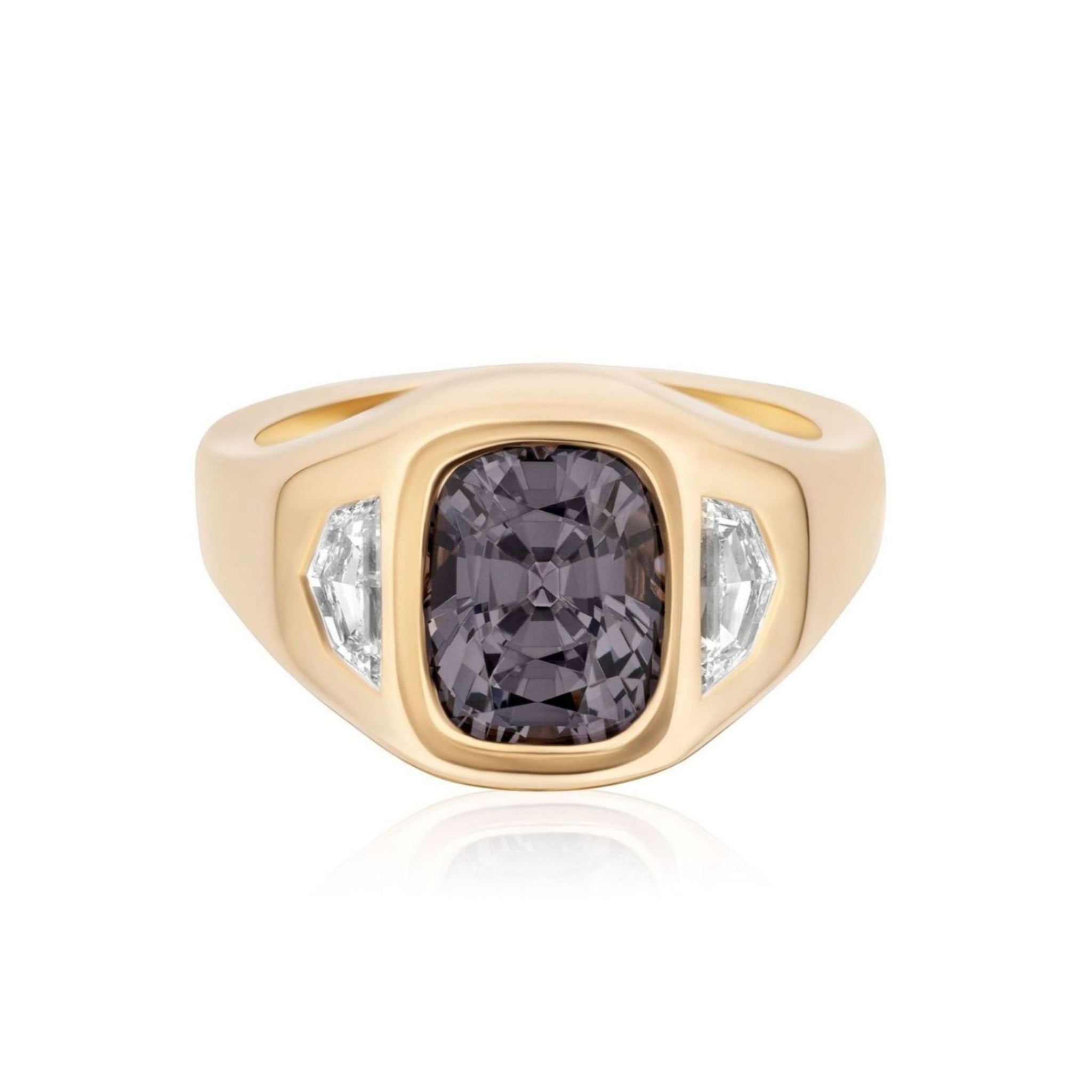 The Cushion Cut Spinel and Diamond Epaulette Side Stone Gypsy Ring in Yellow Gold showcases an elegant 18k yellow gold band with a prominent cushion-cut spinel in a deep, rich purple at its center, accented by two brilliant diamond side stones. All gemstones are set within the ring’s wide, polished band for a striking and sophisticated appearance.