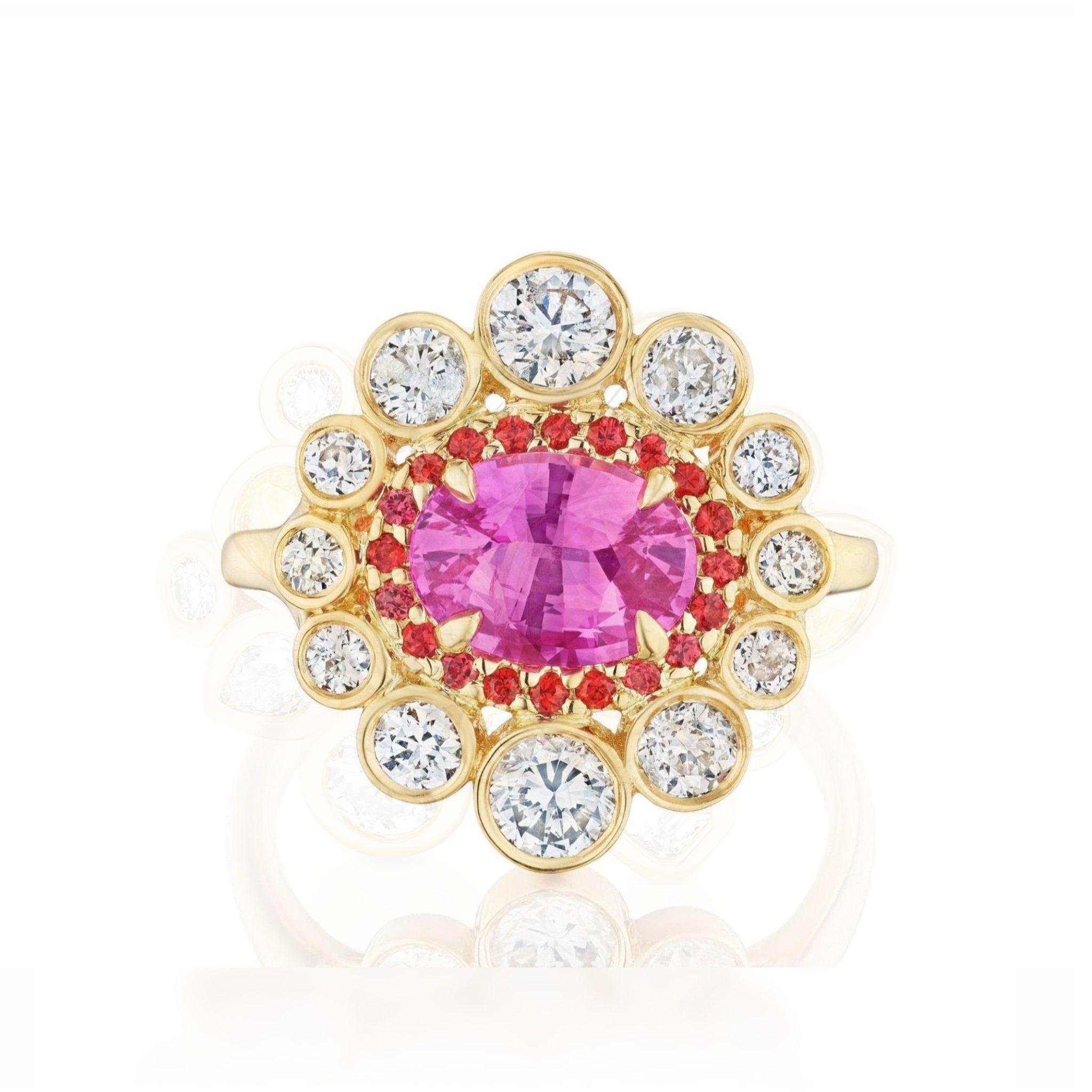 Cocktail Ring in Yellow Gold featuring an east-west set oval pink sapphire at the center, encircled by a halo of small red stones and a border of round white diamonds in an elegant floral design.