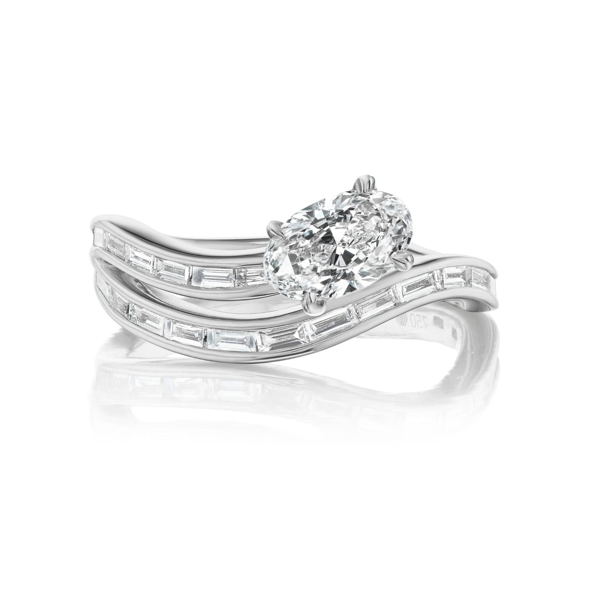 The Snake Wave Channel Set Baguette Diamond Ring with Oval Diamond features a large oval-cut diamond set in white gold or platinum, accompanied by two curved bands adorned with channel-set baguette diamonds, shown against a white background.