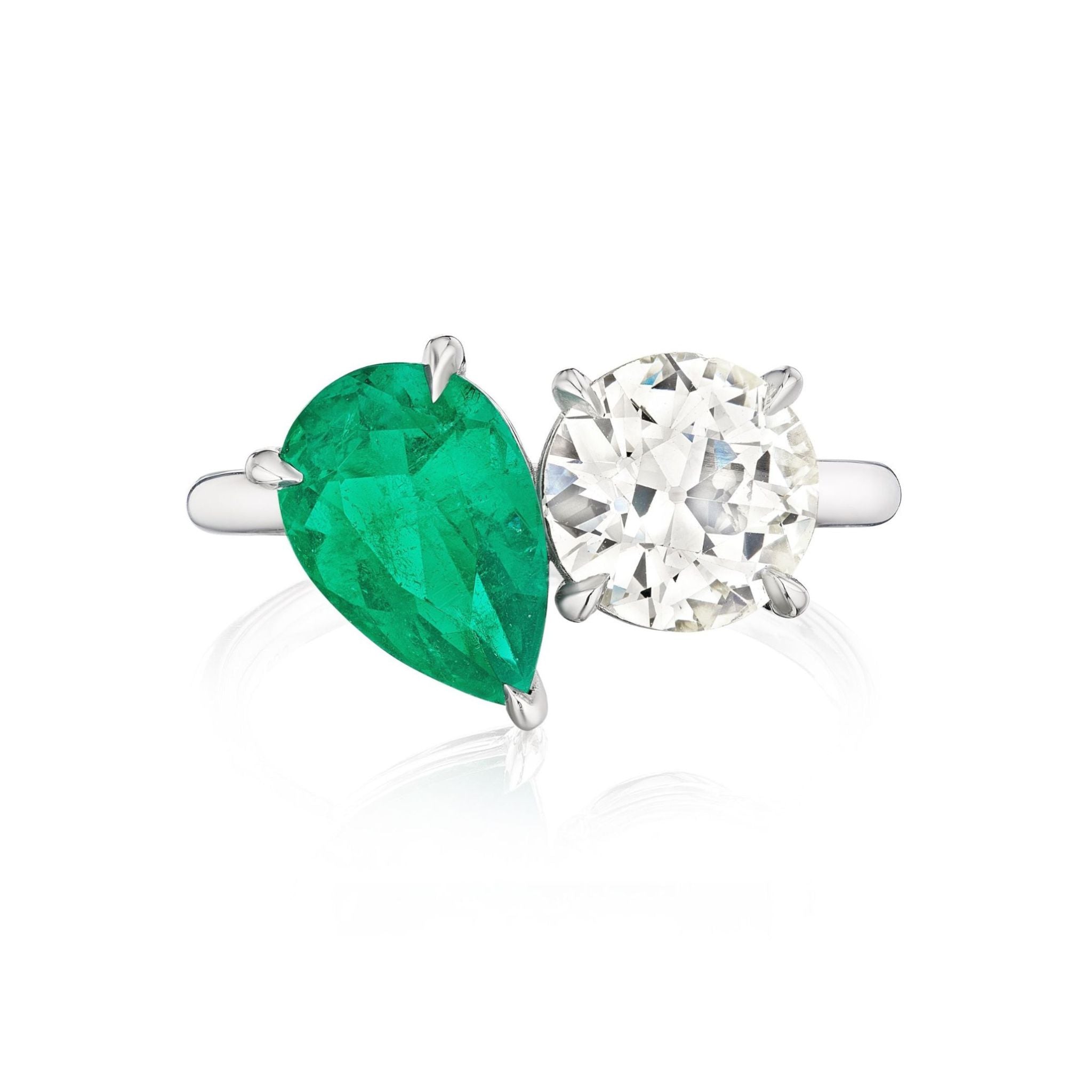 A beautiful Toi et Moi Pear Shape Emerald and Round Diamond Engagement Ring in White Gold, featuring a pear-shaped emerald and a round white diamond set side by side on a classic white gold band, elegantly photographed against a white background.