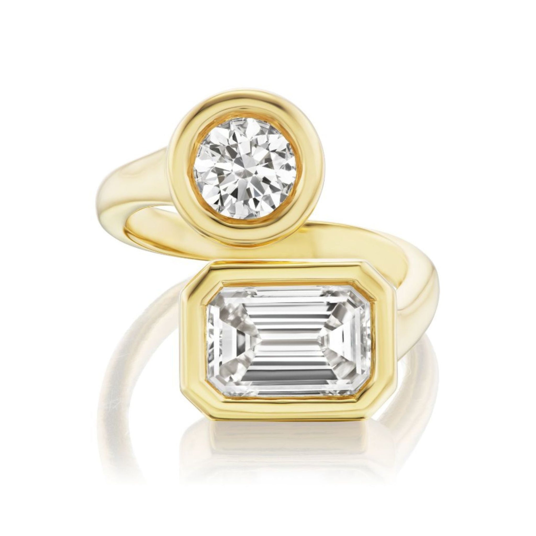 Certainly! Here’s a rewritten version of the sentence using the provided product data: The Toi et Moi Diamond Wraparound Ring features a round cut diamond alongside a larger rectangular emerald-cut diamond, both elegantly bezel set in luxurious 18k yellow gold.