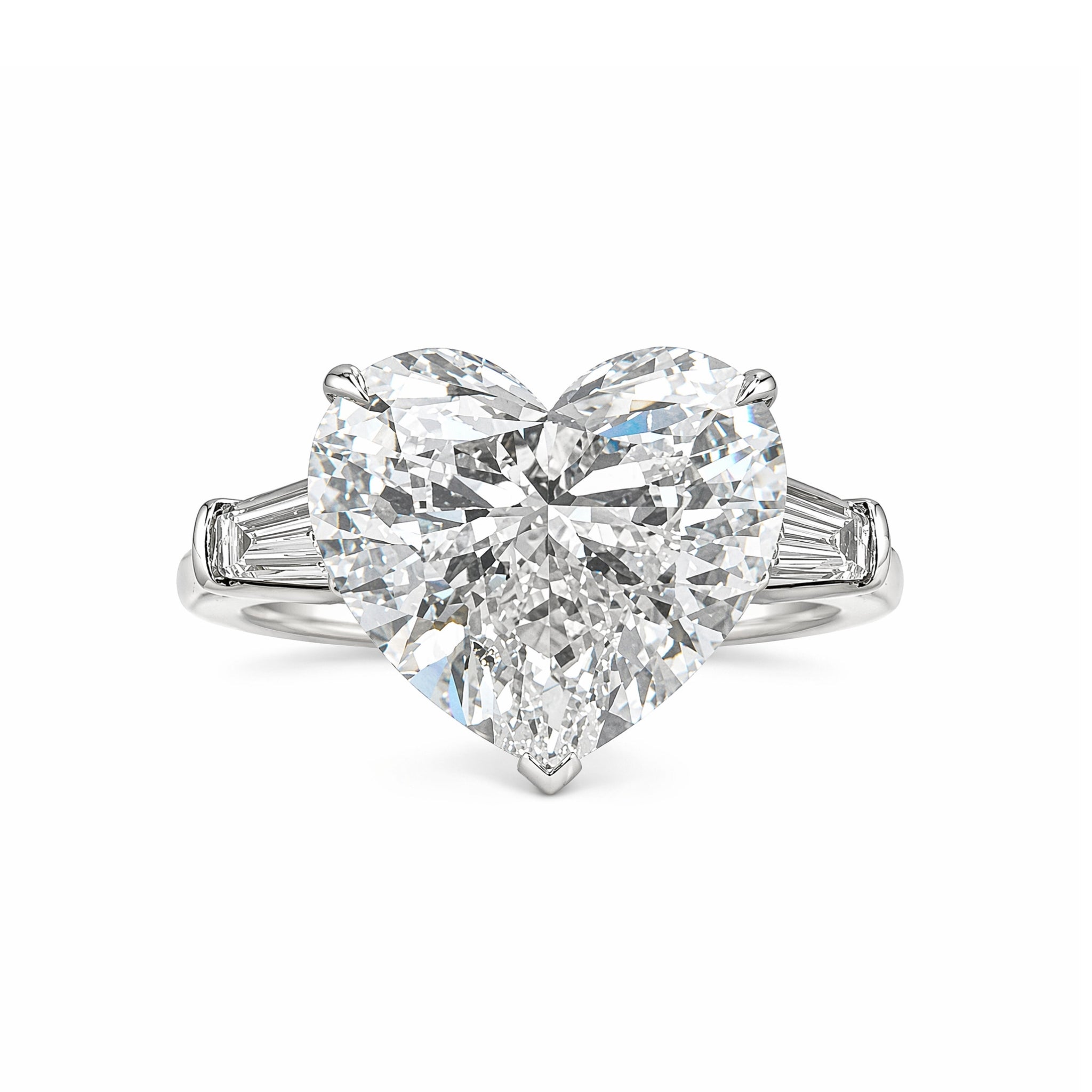 A Heart Shape Diamond Engagement Ring featuring bezel set tapered baguette side stones on a slender platinum band, showcased against a white background.