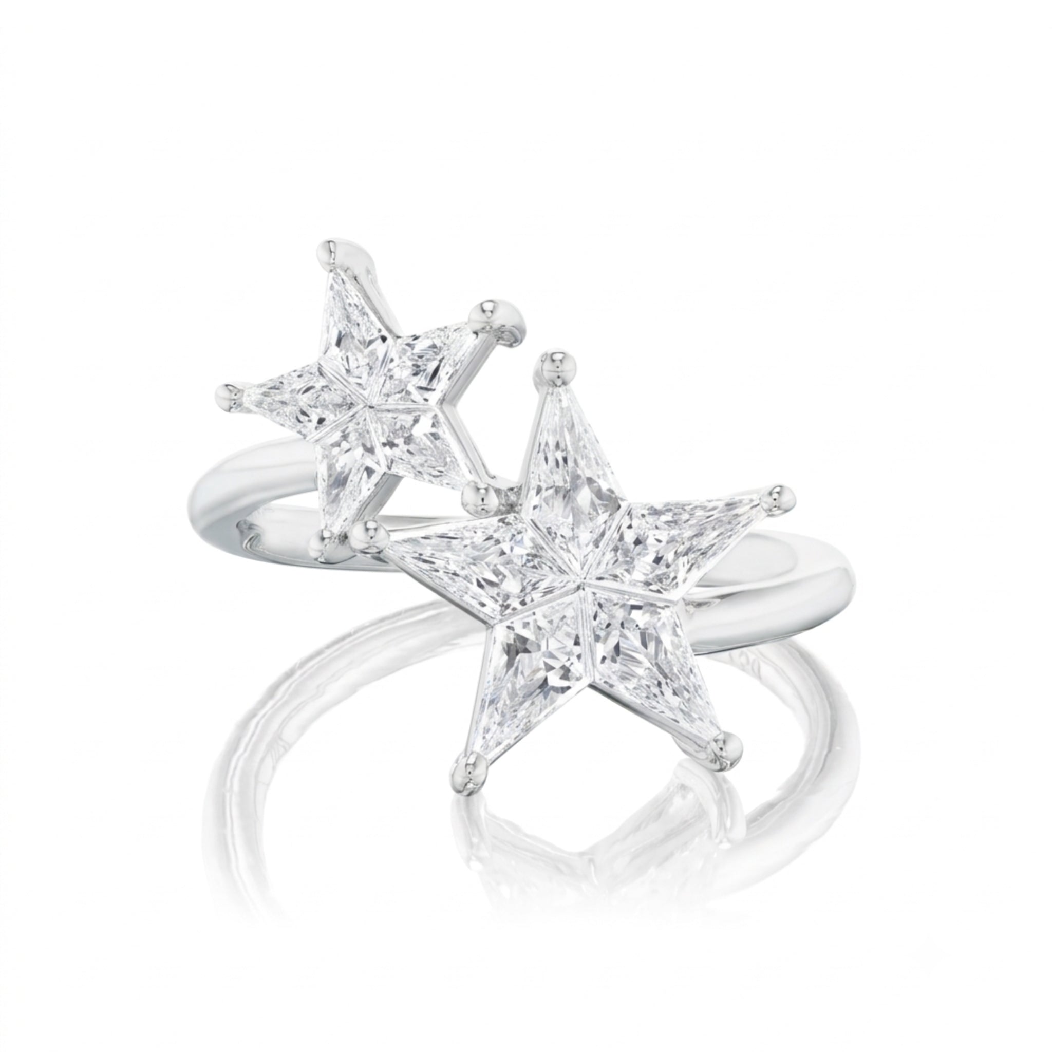 The Celestial Shooting Stars Wraparound Ring with Kite Diamonds features two sparkling, five-pointed star designs set on an open silver band. Shown here as part of the Celestial Collection, the ring is photographed against a white background with a mirrored reflection below.