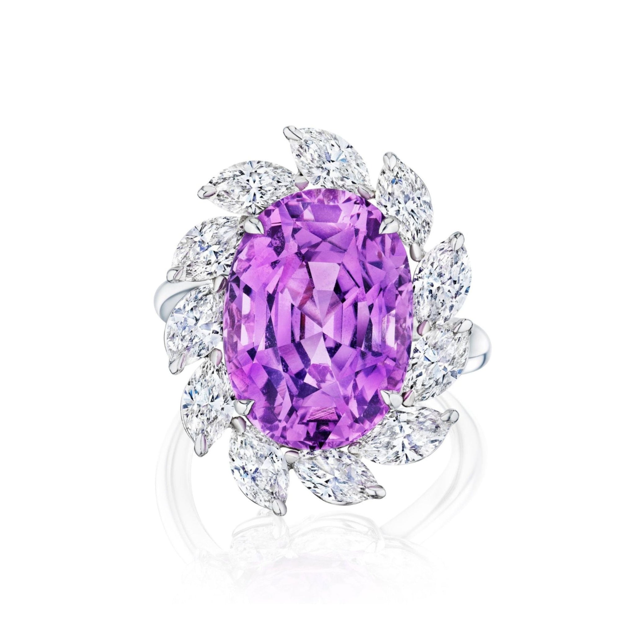 Introducing the Sunburst Cocktail Ring, showcasing a striking oval sapphire encircled by a radiant halo of marquise and round diamonds that evoke the look of petals.