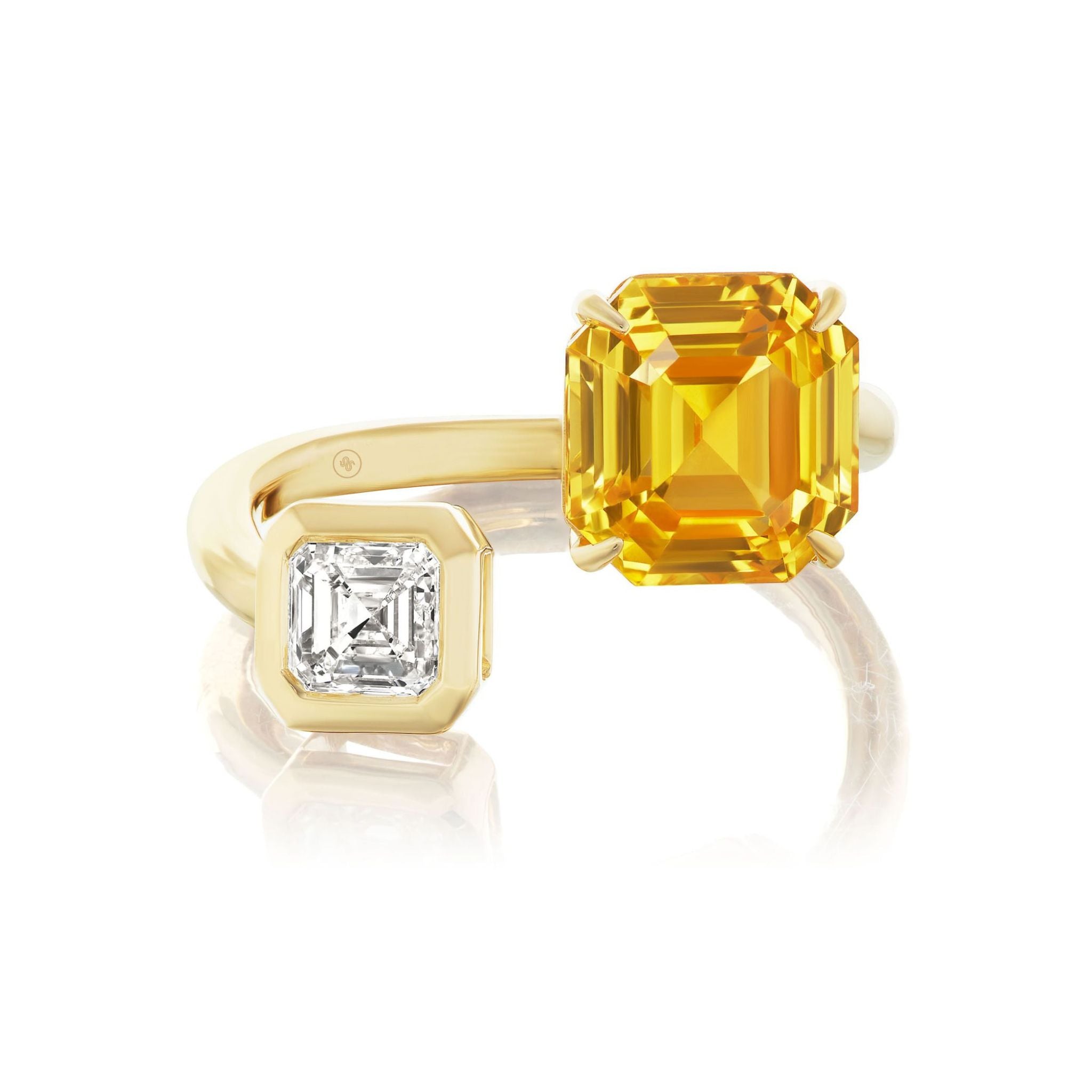 The Yellow Sapphire and Diamond Toi et Moi Ring is crafted in 18k yellow gold with an open band design, showcasing a large rectangular yellow sapphire on one end and a smaller Asscher cut diamond on the other.