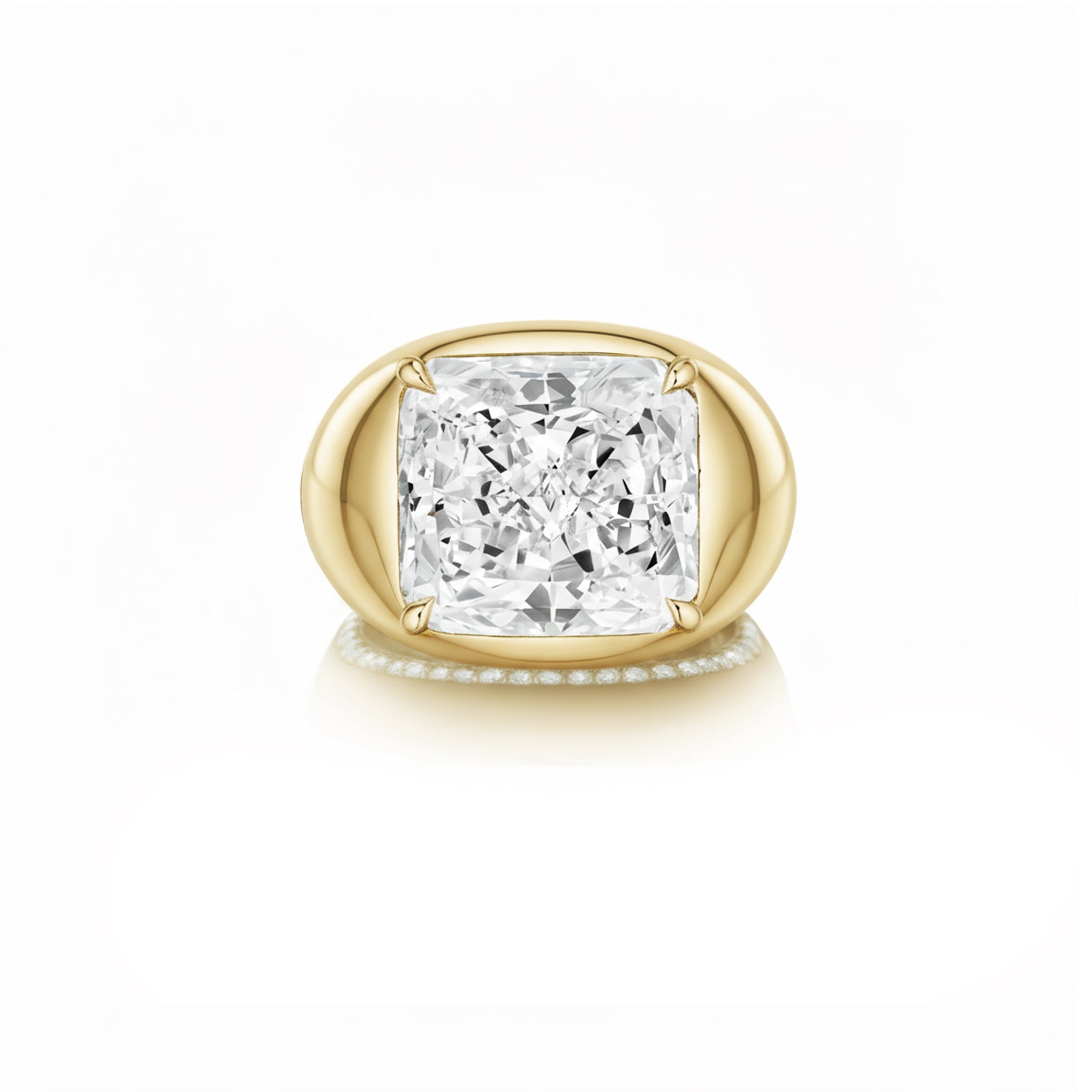 The Chunky Cushion Cut Diamond Engagement Ring features a large cushion-cut center diamond and a yellow gold band with round diamond side stones, shown against a white background.