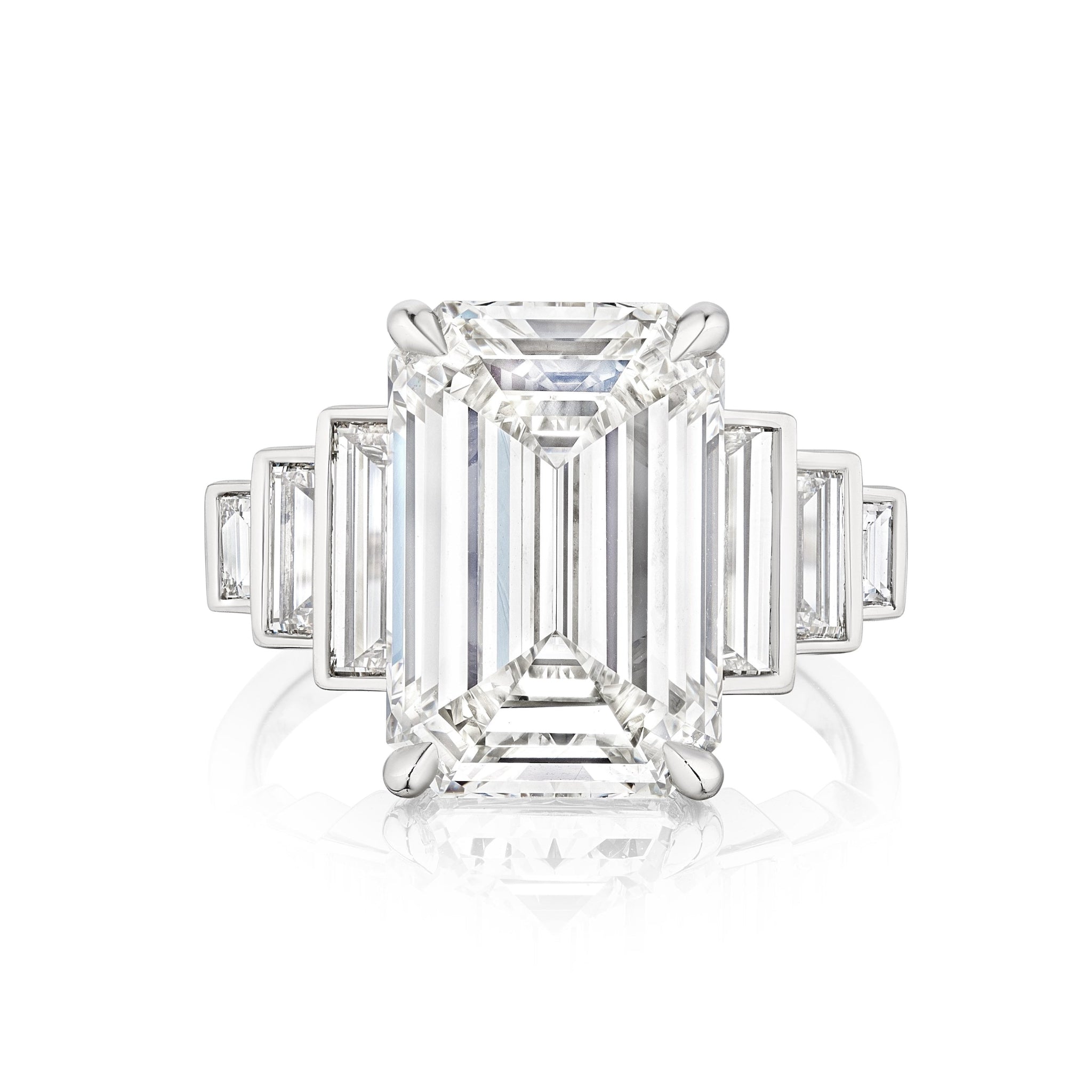 The Triple Echo Emerald Cut Diamond Engagement Ring showcases a striking emerald-cut center stone with bezel-set baguette side stones, all in a timeless and elegant platinum design.