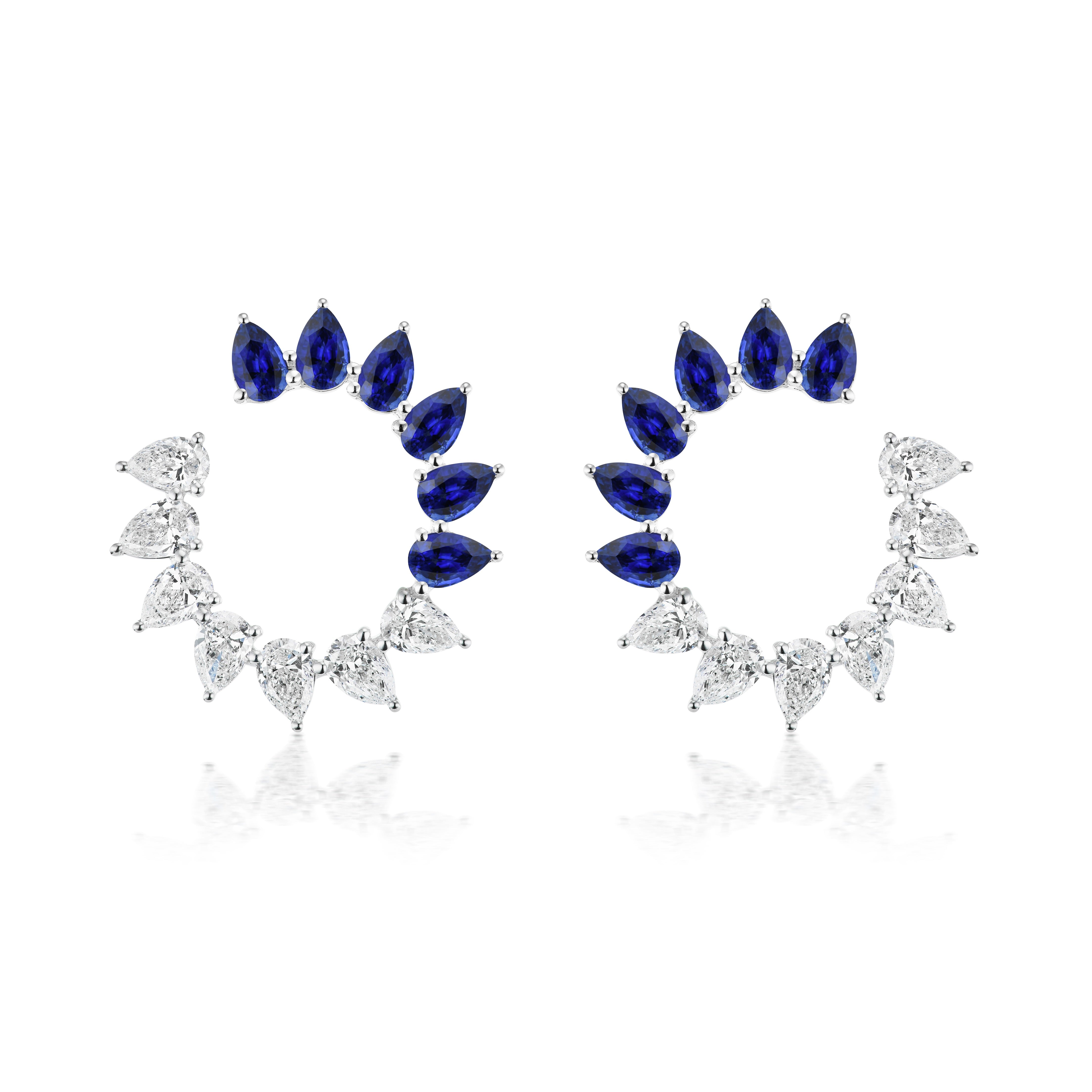 The Sunshine Front-to-Back Earrings feature pear-shaped blue sapphires and diamonds set in symmetrical 18K white gold circles, each with an open center for a striking look.
