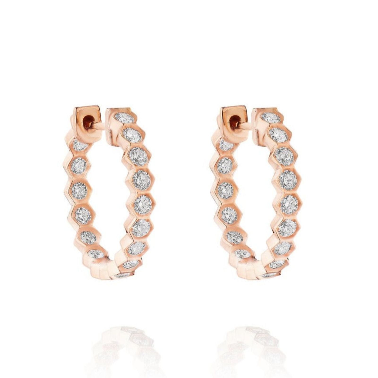 The Bezel Set Hexagon Huggies feature 18K gold in a scalloped design, set with round brilliant diamonds along the front. They are displayed on a white background.