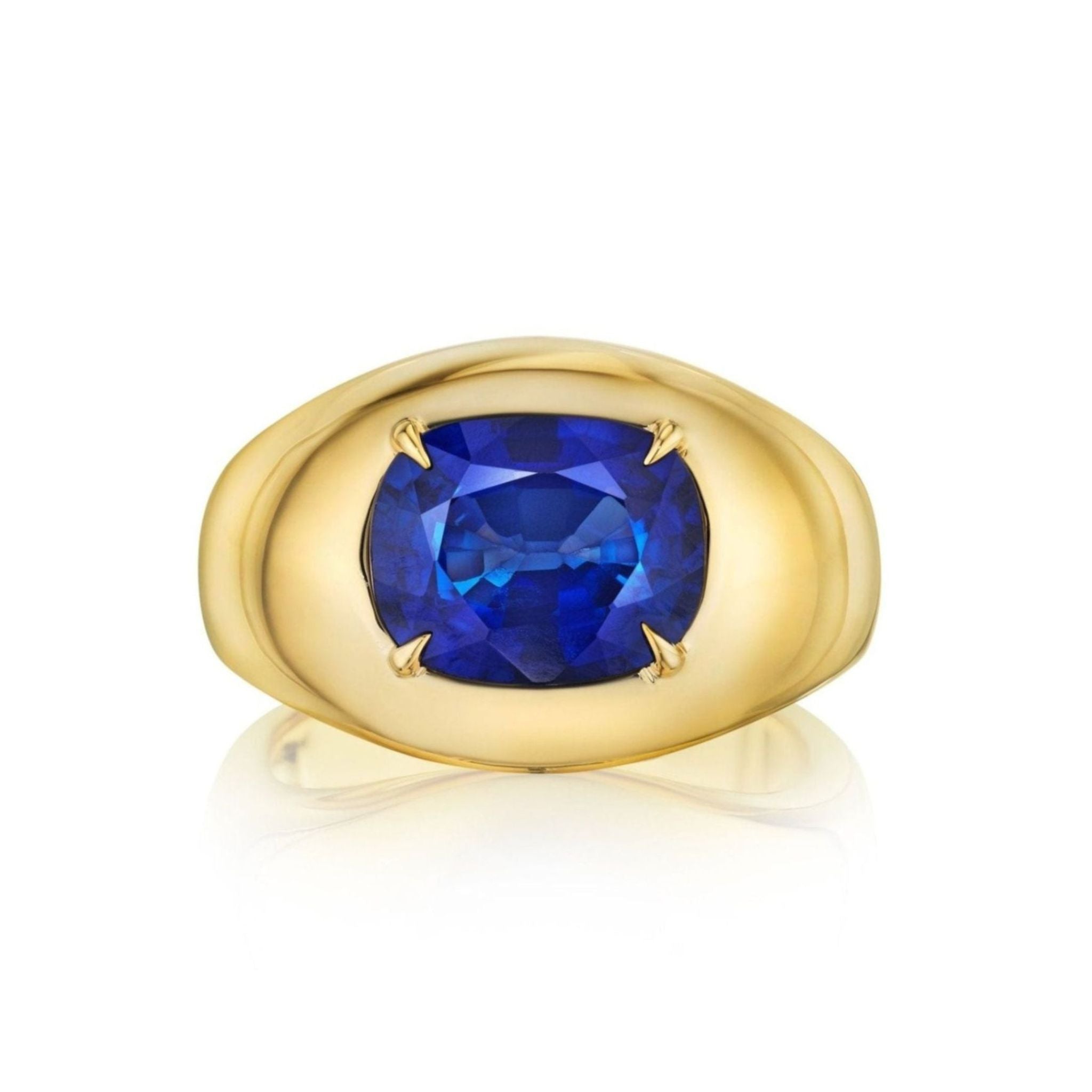 A striking example of maximalist jewelry, the Oval Gemstone Bombé Ring in Yellow Gold showcases a large, cushion-cut blue sapphire at its center, displayed elegantly against a white background.
