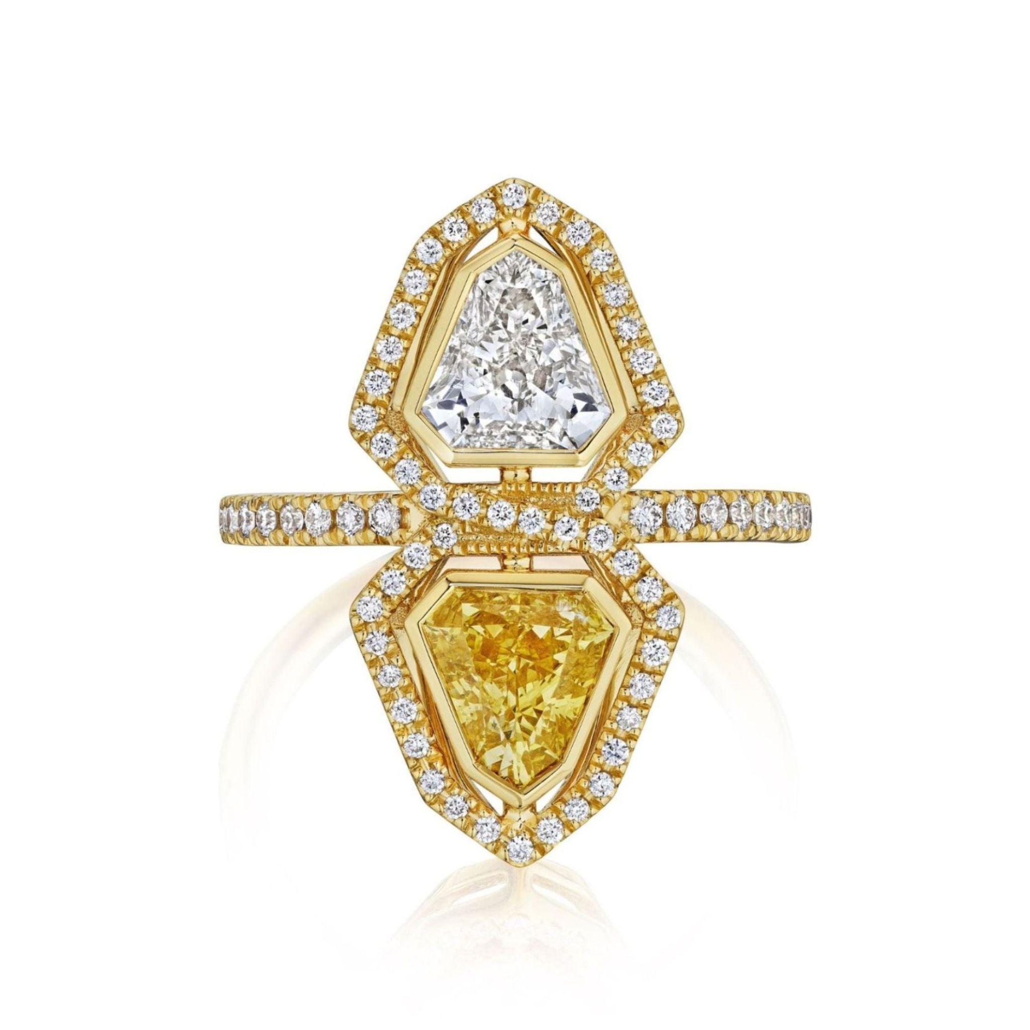The Yellow Diamond and White Diamond Double Shield Ring with Halo in Yellow Gold features two large geometric shield diamonds—one white and one yellow—each encircled by a halo of smaller diamonds. Set on an 18k yellow gold band accented with additional diamonds, the band splits to elegantly frame the stones in a modern, symmetrical design.
