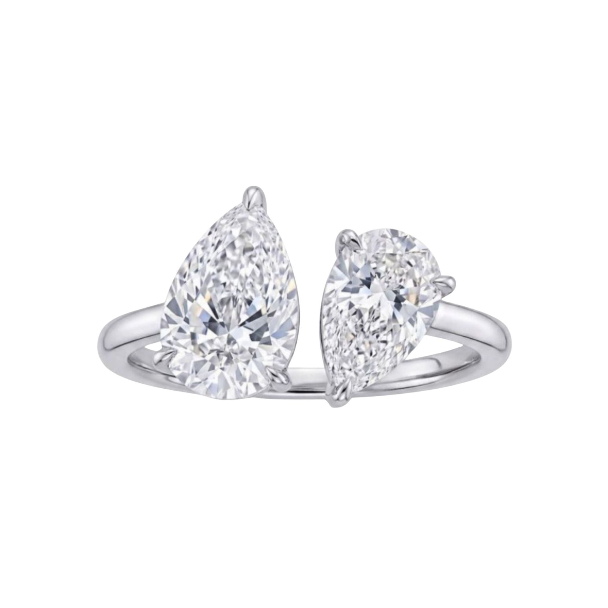 The Toi et Moi Pear Diamond Ring in White Gold showcases two pear-shaped diamonds—one larger than the other—set side by side on a slender, polished 18k white gold band, displayed against a white background.
