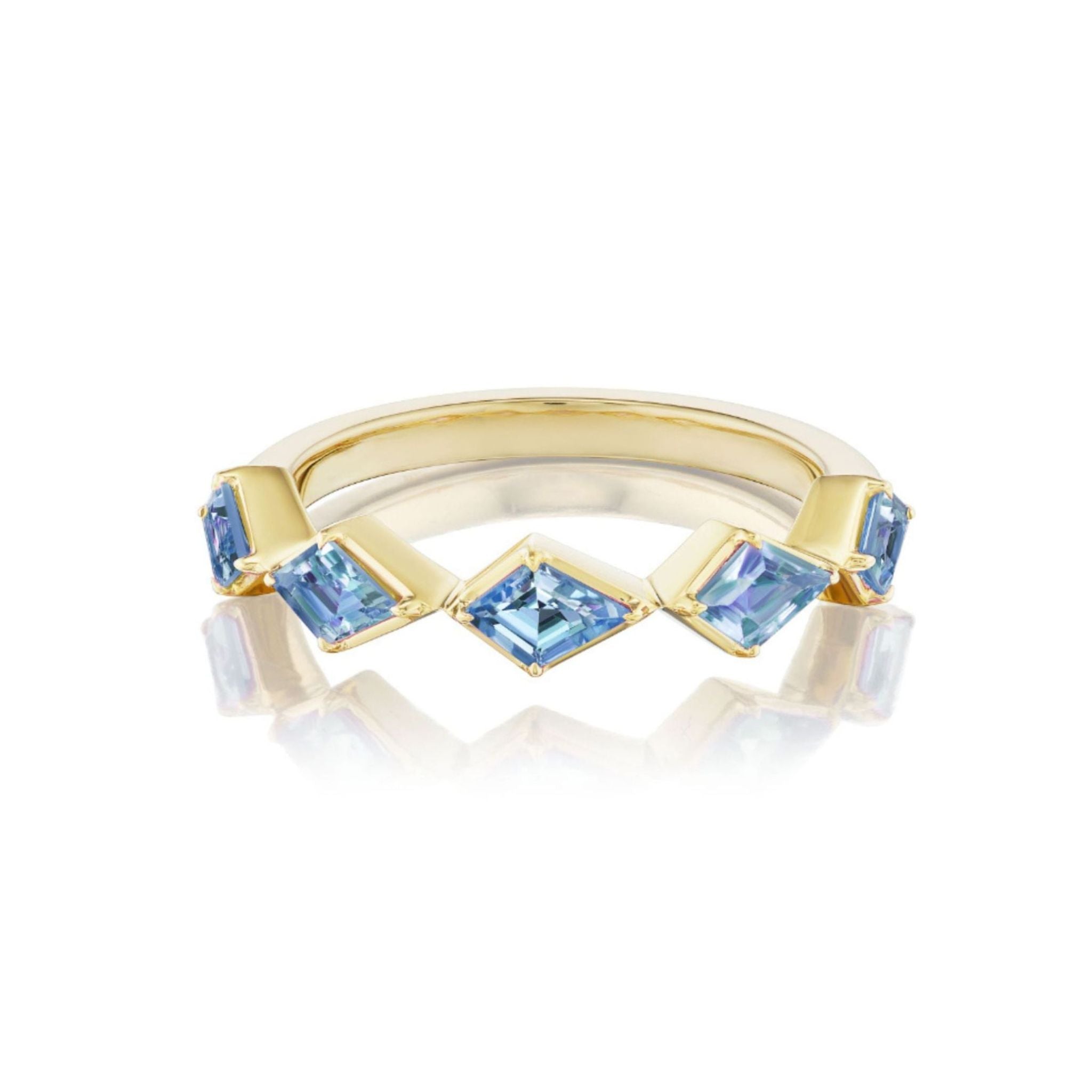 The Chasing Kites Light Blue Sapphire Half Eternity Band, crafted in 18k yellow gold and featuring five square-cut blue sapphires arranged in a striking zigzag pattern, is beautifully showcased on a white reflective surface.