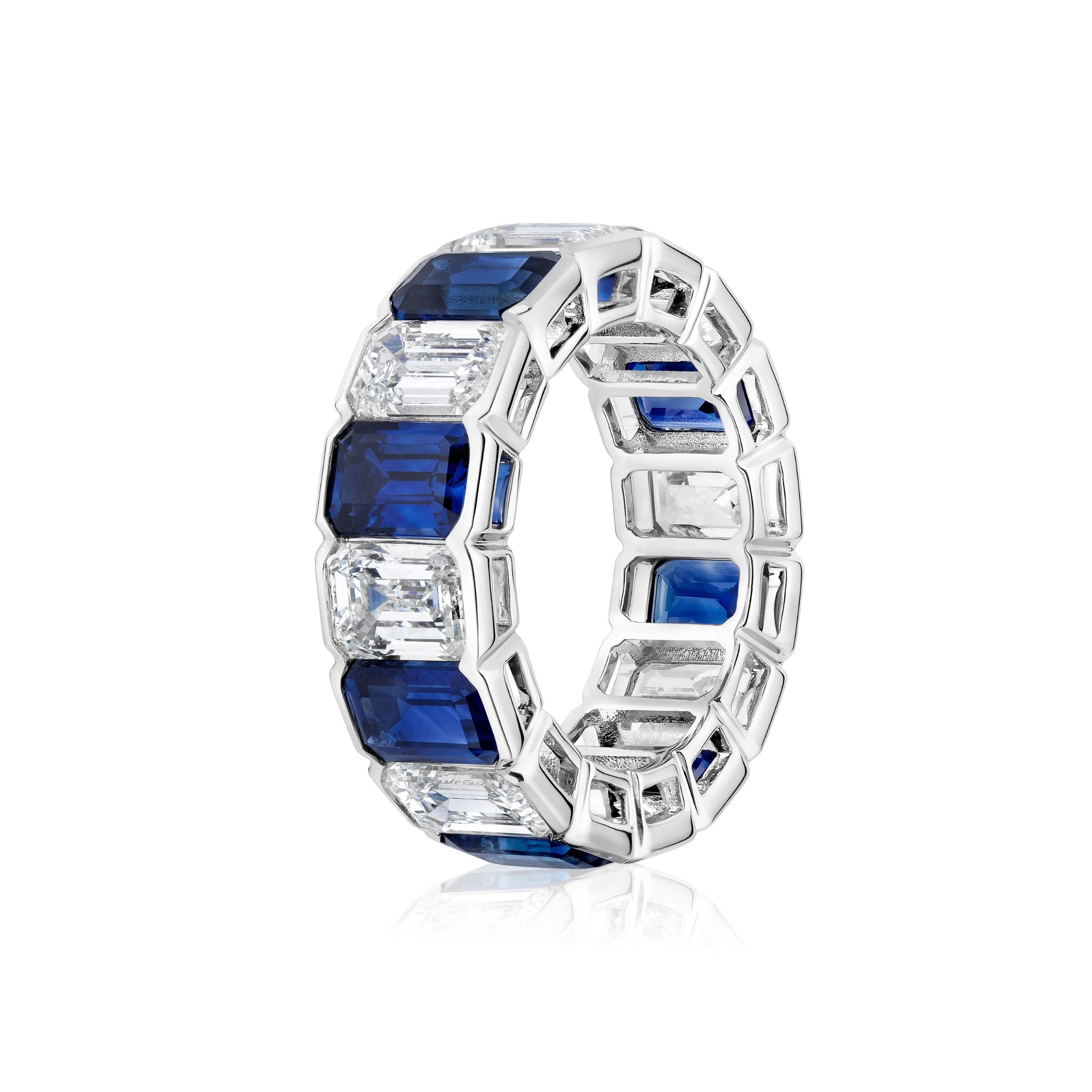 Introducing the Alternating Half-Bezel Emerald Cut Diamond and Sapphire Eternity Band—a platinum ring featuring a continuous band of alternating emerald-cut blue sapphires and white diamonds.