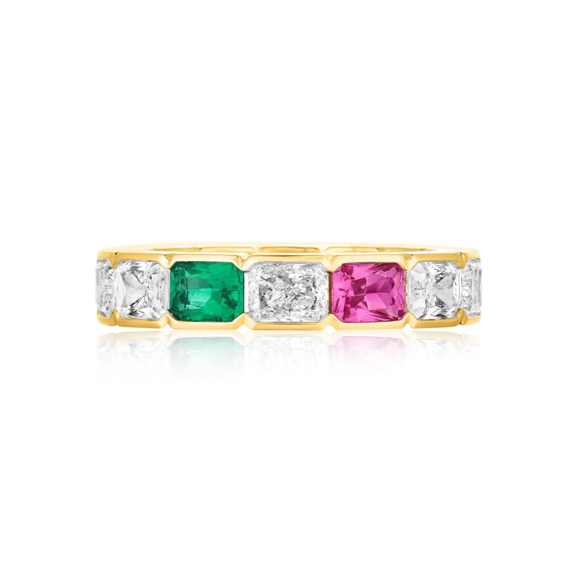 Introducing the East-West Half-Bezel Set Radiant Cut Diamond, Emerald, and Sapphire Eternity Band in Yellow Gold—a striking 18k yellow gold ring showcasing radiant cut diamonds, vivid green emeralds, and a bold pink sapphire set alternately in a sleek east-west row.