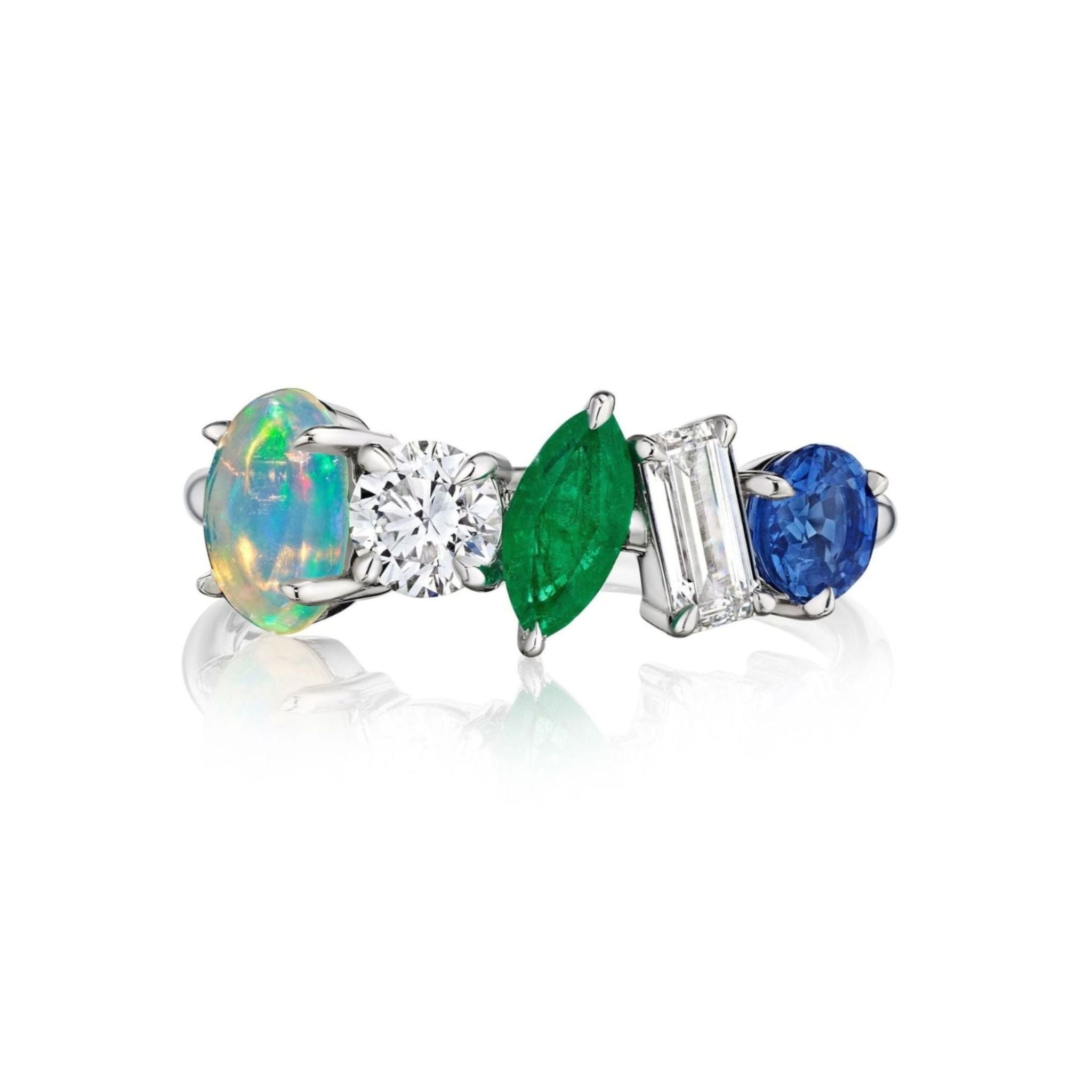 The Mixed Shape Opal, Emerald, Diamond, and Sapphire Half-Eternity Band showcases a striking silver setting adorned with five exquisite gemstones—an opal, round diamond, marquise emerald, baguette diamond, and round blue sapphire—arranged side by side in an artful composition. The refined design highlights the radiant sparkle of the diamonds and the opal's luminous charm, making this band a captivating statement piece.