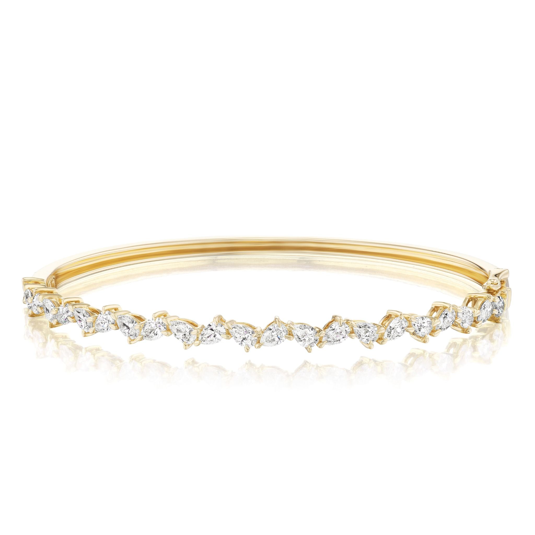 The Alternating Pear Shape Diamond Bangle in Yellow Gold features a row of G-H color, marquise-cut and round diamonds set in a delicate, alternating pattern across the top.