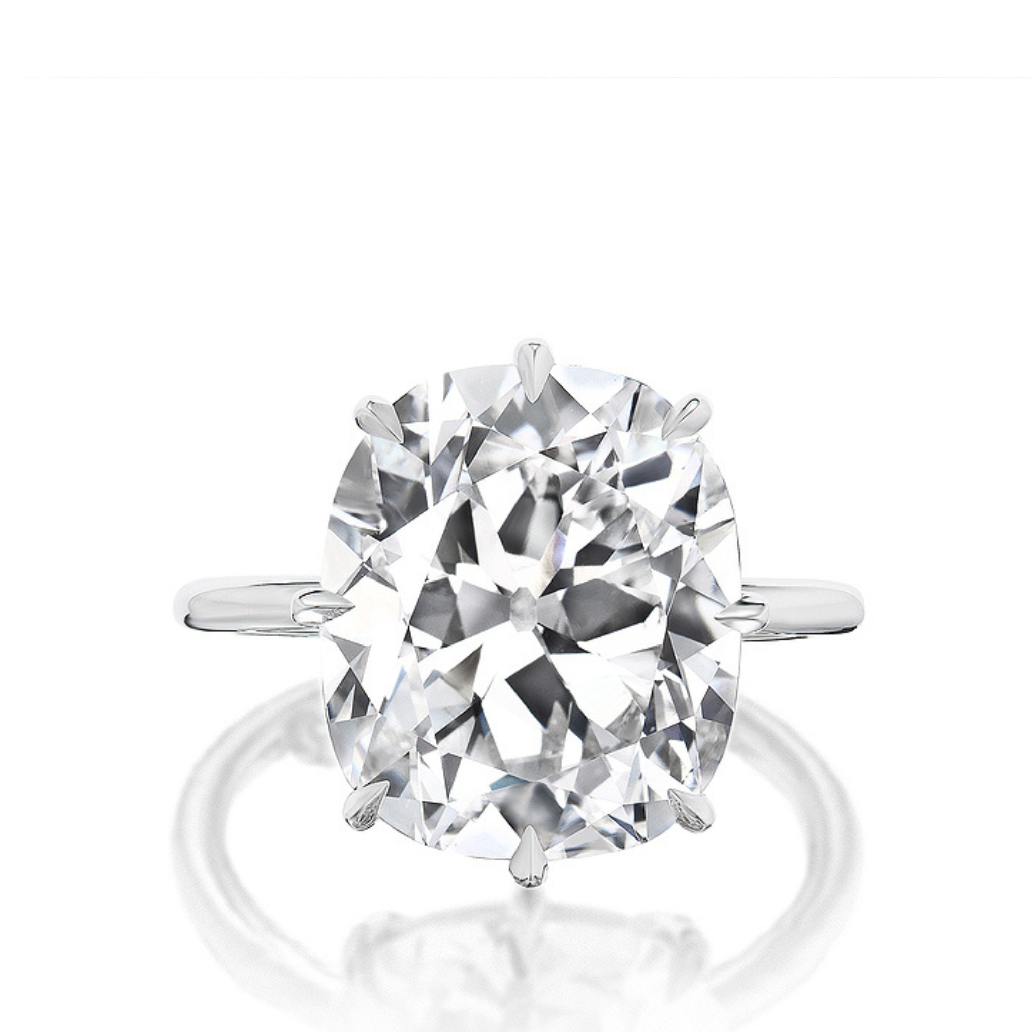 The Antique Cushion Cut Diamond Solitaire Engagement Ring features a large, cushion-cut diamond set in a classic prong setting on a simple band, showcased elegantly against a white background.